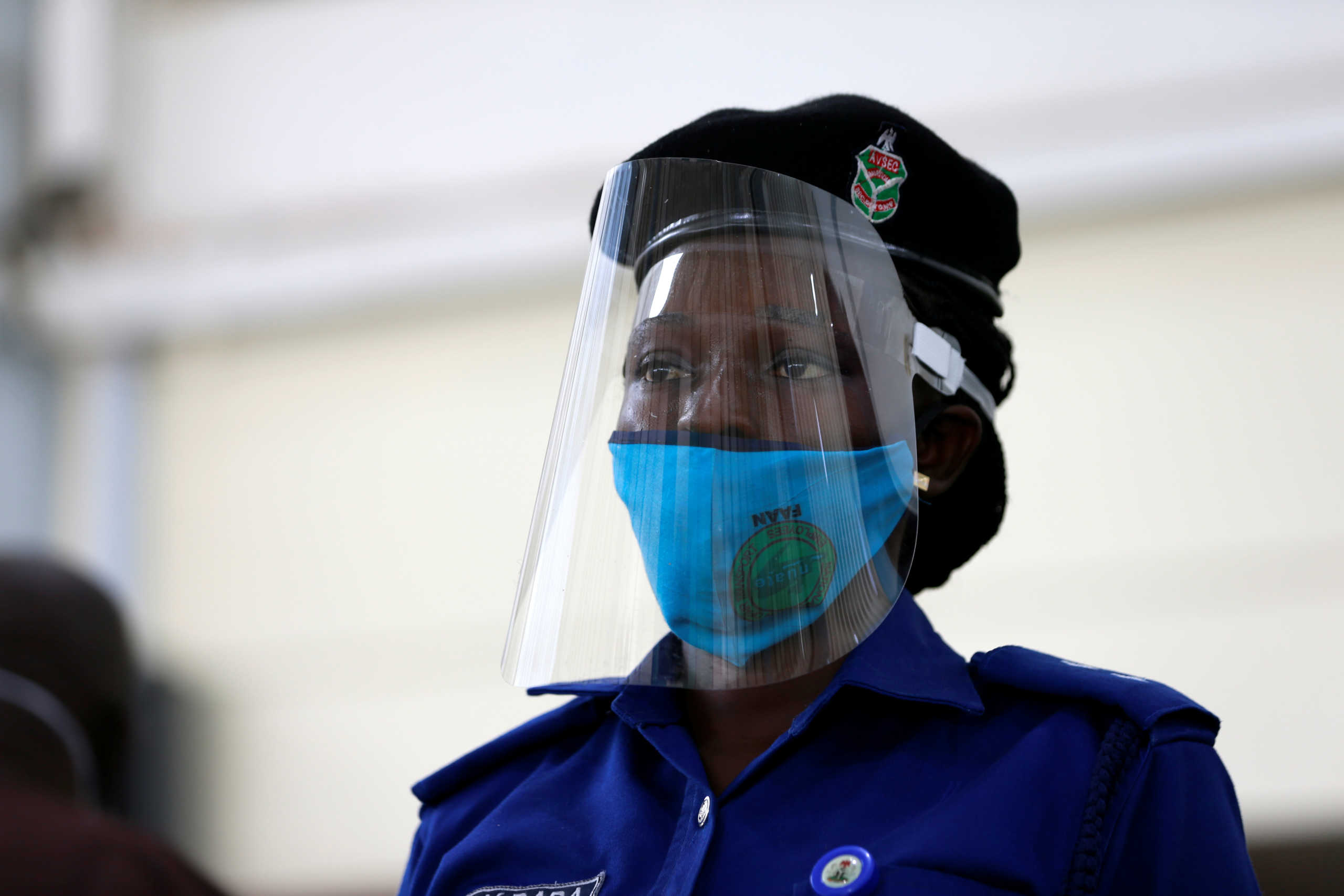 Airport security staff wears a protective shield and a face mask at the domestic wing of Nnamdi Azikiwe International Airport during preparation ahead of the reopening of the airport for domestic flight operations that is scheduled for July 8, 2020 in Abuja, Nigeria July 6, 2020. REUTERS