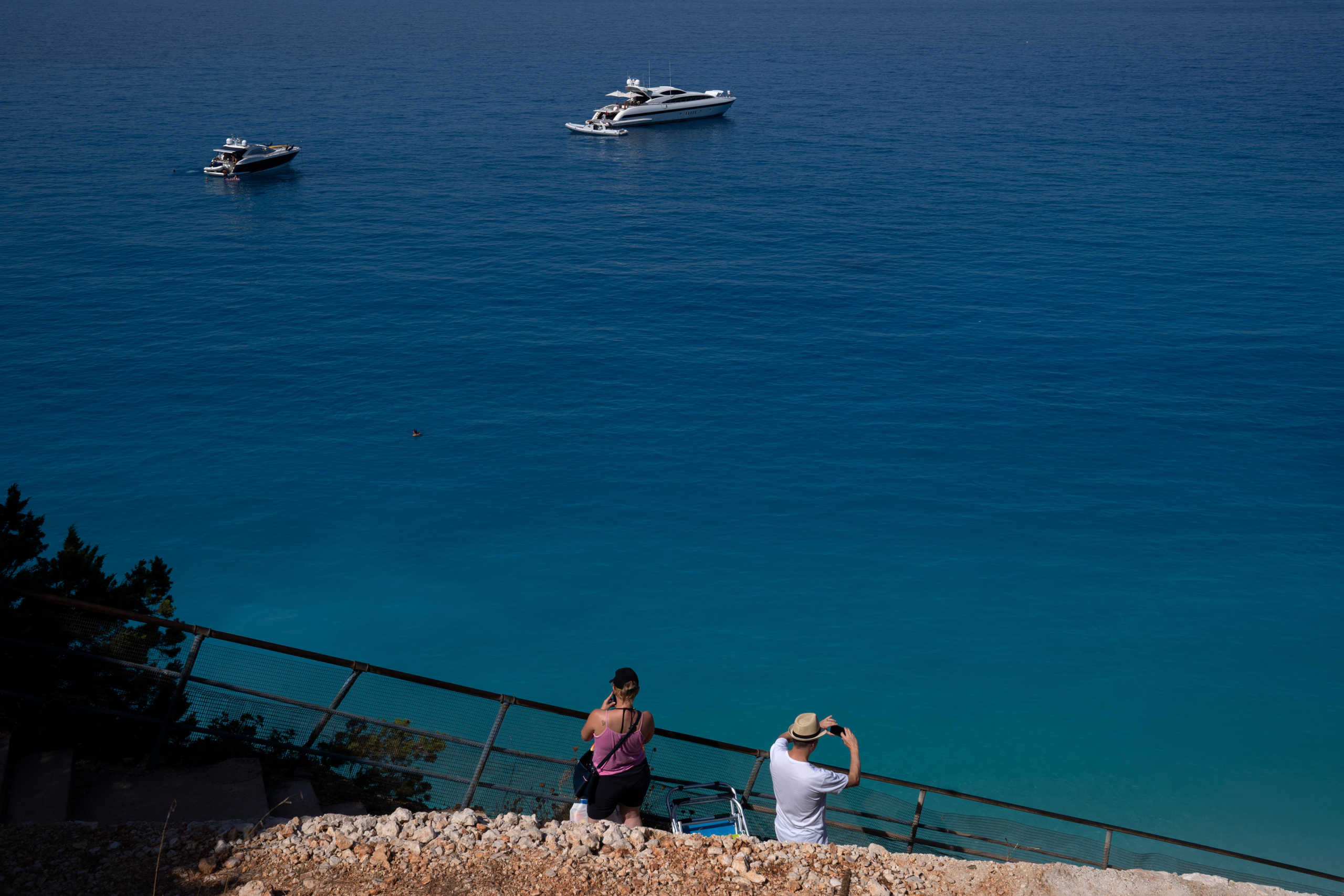 People take photos at Porto Katsiki beach, following the easing of measures against the spread of the coronavirus disease (COVID-19), on the island of Lefkada, Greece, July 25, 2020. Picture taken July 25, 2020. REUTERS
