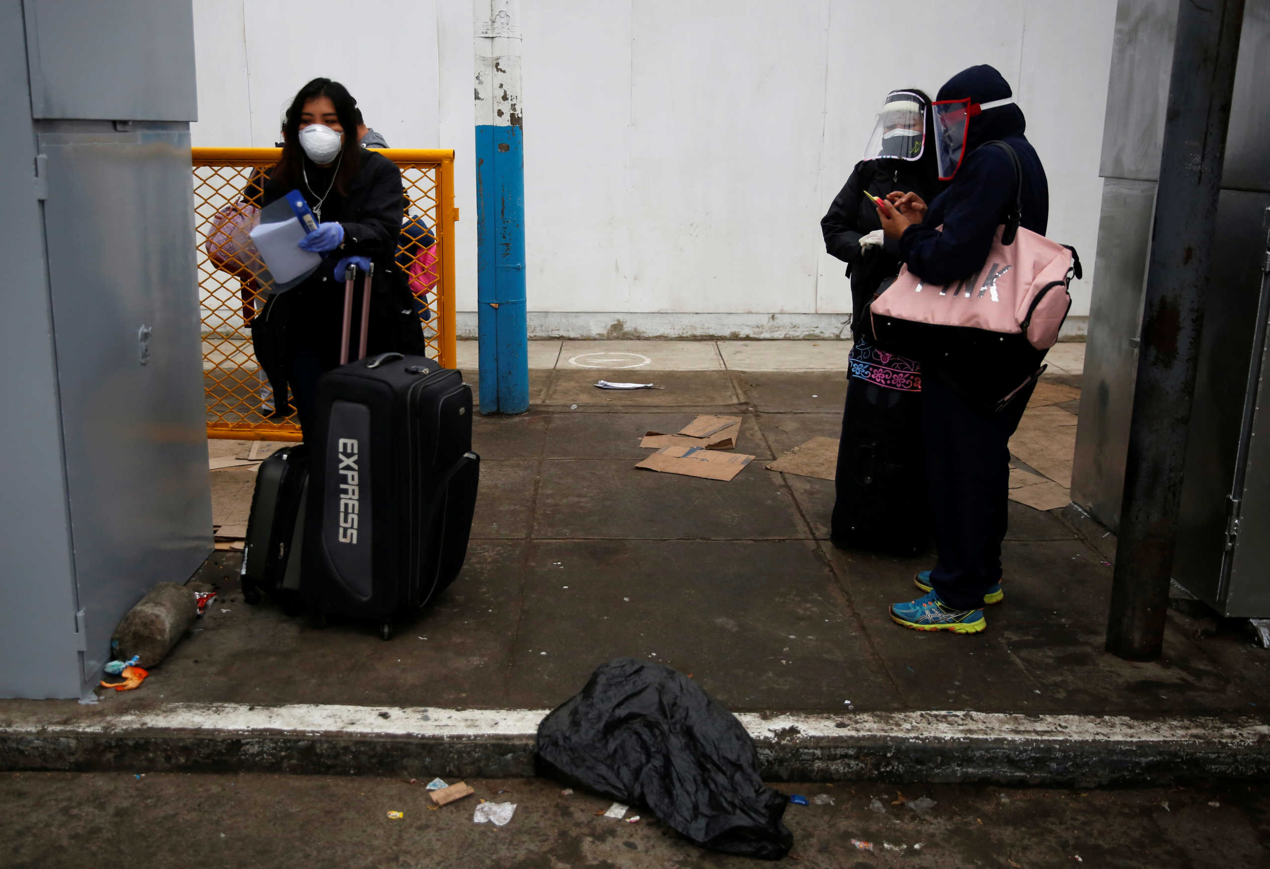 Passengers wearing face masks and face shields stand outside the airport, during the outbreak of the coronavirus disease (COVID-19), in Lima, Peru July 15, 2020. REUTERS