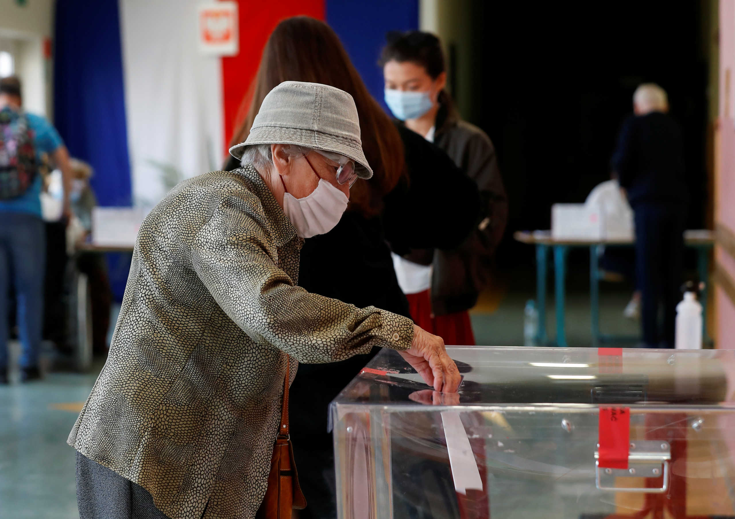 A voter wearing a protective mask casts a ballot during the second round of presidential election at a polling station in Warsaw, Poland, July 12, 2020. REUTERS