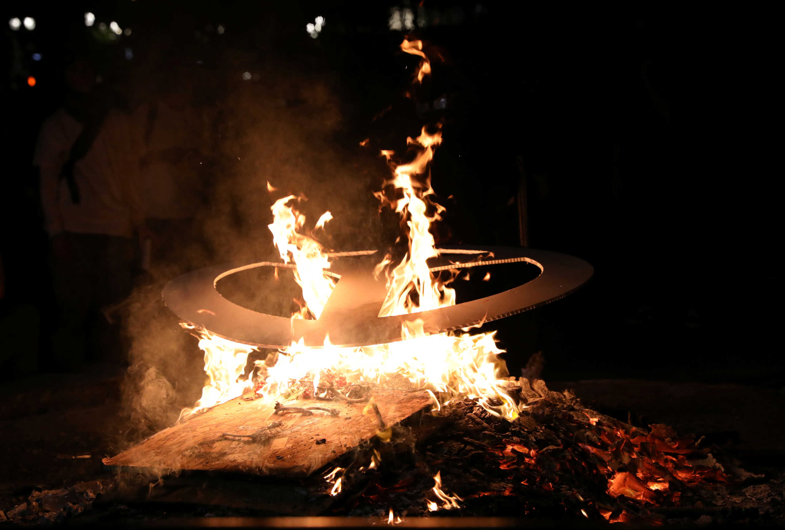 A demonstrator burns a peace sign during a protest against racial inequality in Portland, Oregon, U.S., July 19, 2020. REUTERS