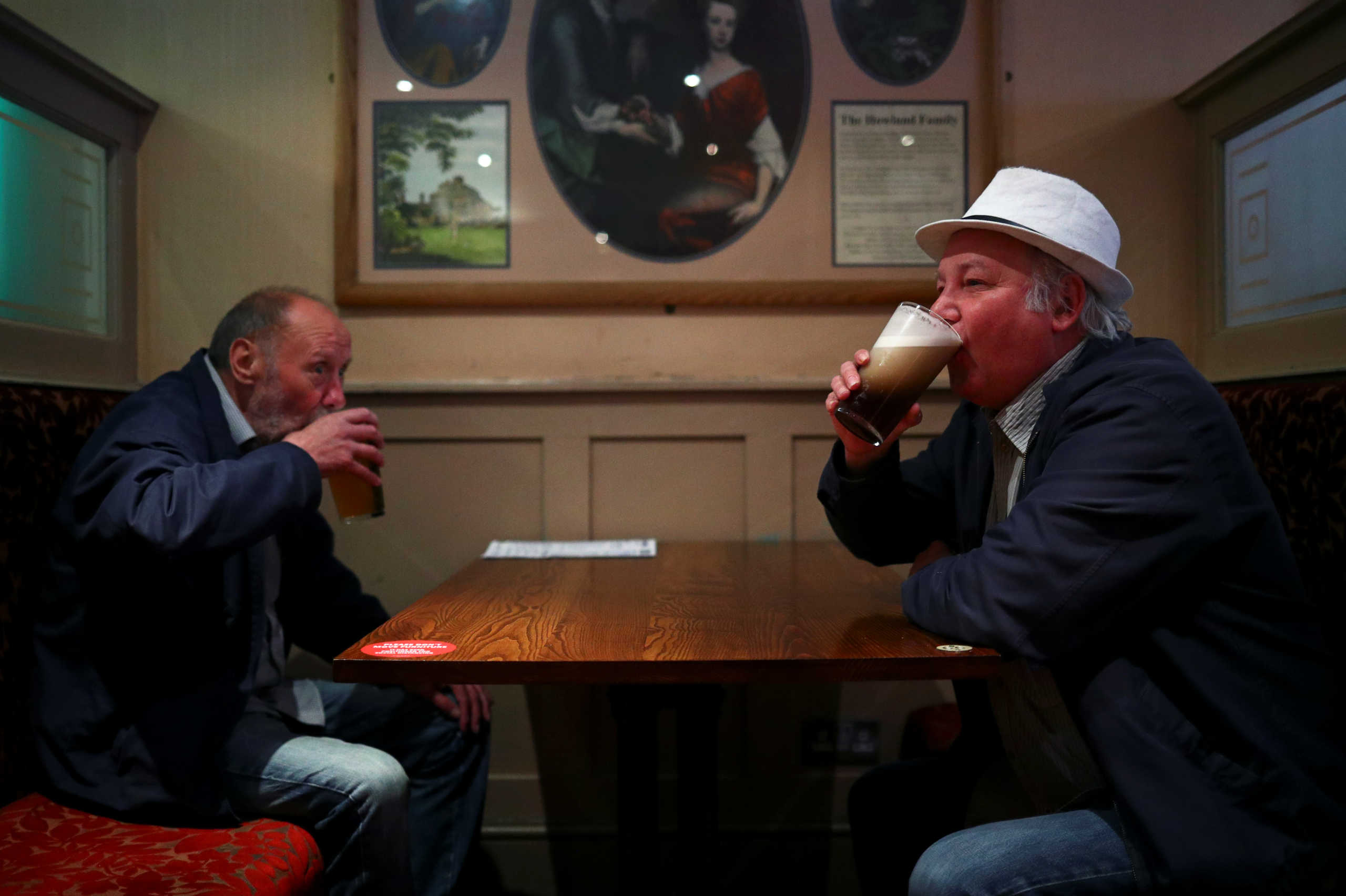 Customers drink beer at The Holland Tringham Wetherspoons pub after it reopened following the outbreak of the coronavirus disease (COVID-19), in London, Britain July 4, 2020. REUTERS