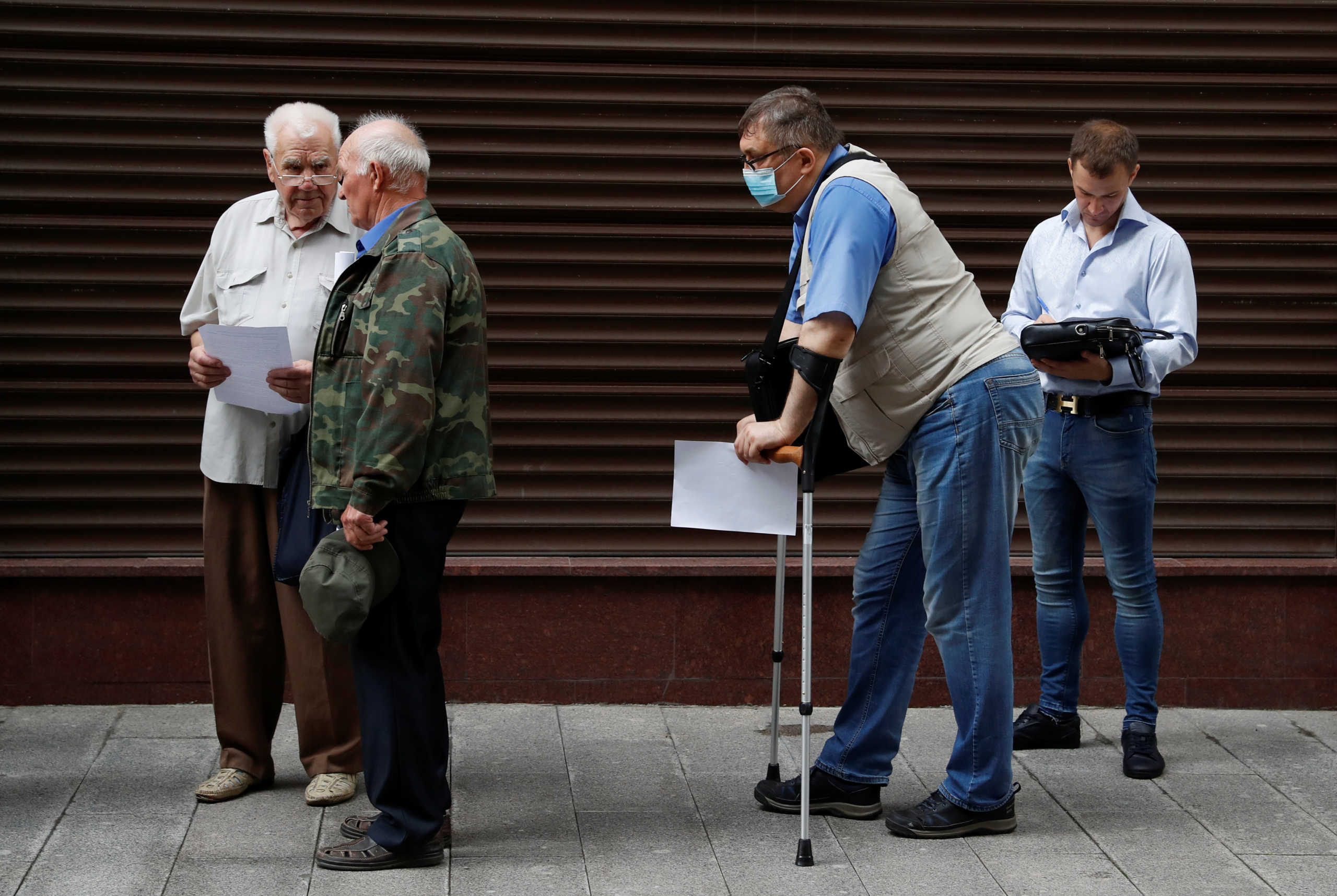 Participants queue outside the presidential administration's office during a gathering, organized by Left Front movement to protest against amendments to Russia's Constitution and to reject the results of a nationwide vote on constitutional reforms, in central Moscow, Russia July 4, 2020. Participants gathered near the office of Russia's presidential administration to file a petition for nonrecognition of the referendum on constitutional changes. REUTERS