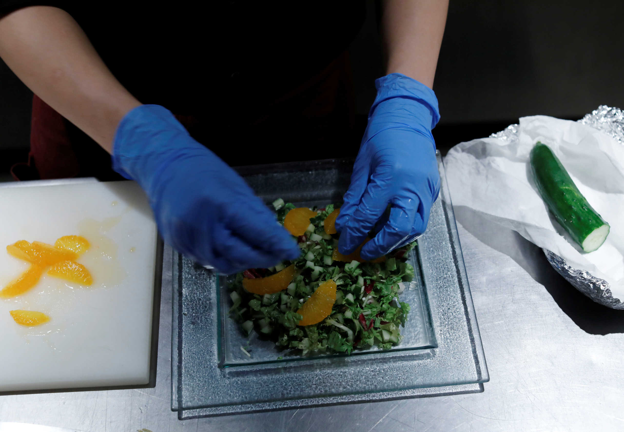 A chef wearing protective gloves amid the coronavirus disease (COVID-19) outbreak, makes a salad at Setouchi Lemon Shokudo in Tokyo, Japan June 22, 2020. Picture taken June 22, 2020. REUTERS