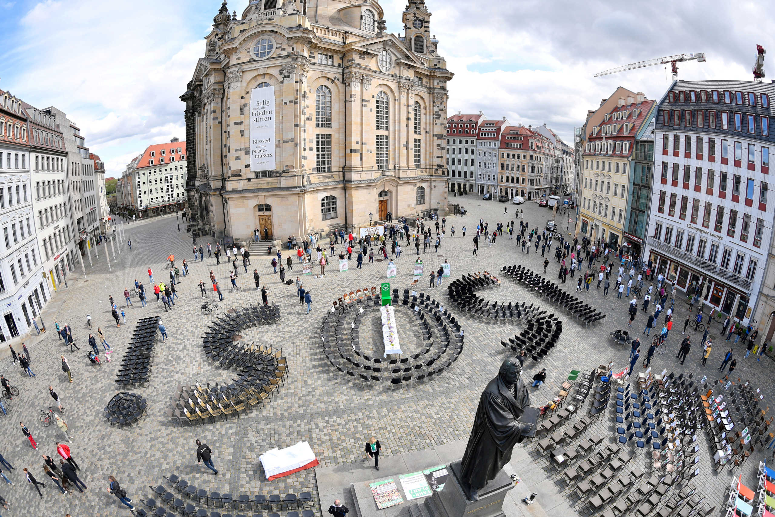 FILE PHOTO: Empty chairs arranged to display "SOS" are placed at the Neumarkt square to call attention to the difficult situation of hotel and restaurant owners, as the spread of the coronavirus disease (COVID-19) continues in Dresden, Germany, May 1, 2020. Picture taken with fisheye lens. REUTERS