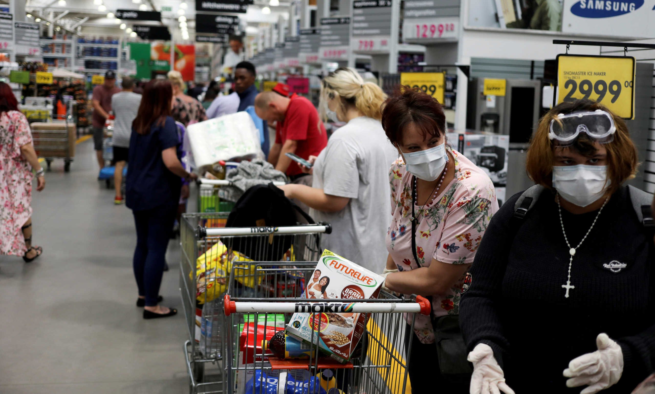 FILE PHOTO: Shoppers stock up on groceries as they wear protective masks to contain coronavirus at a Makro store in Johannesburg, South Africa, March 16, 2020. REUTERS