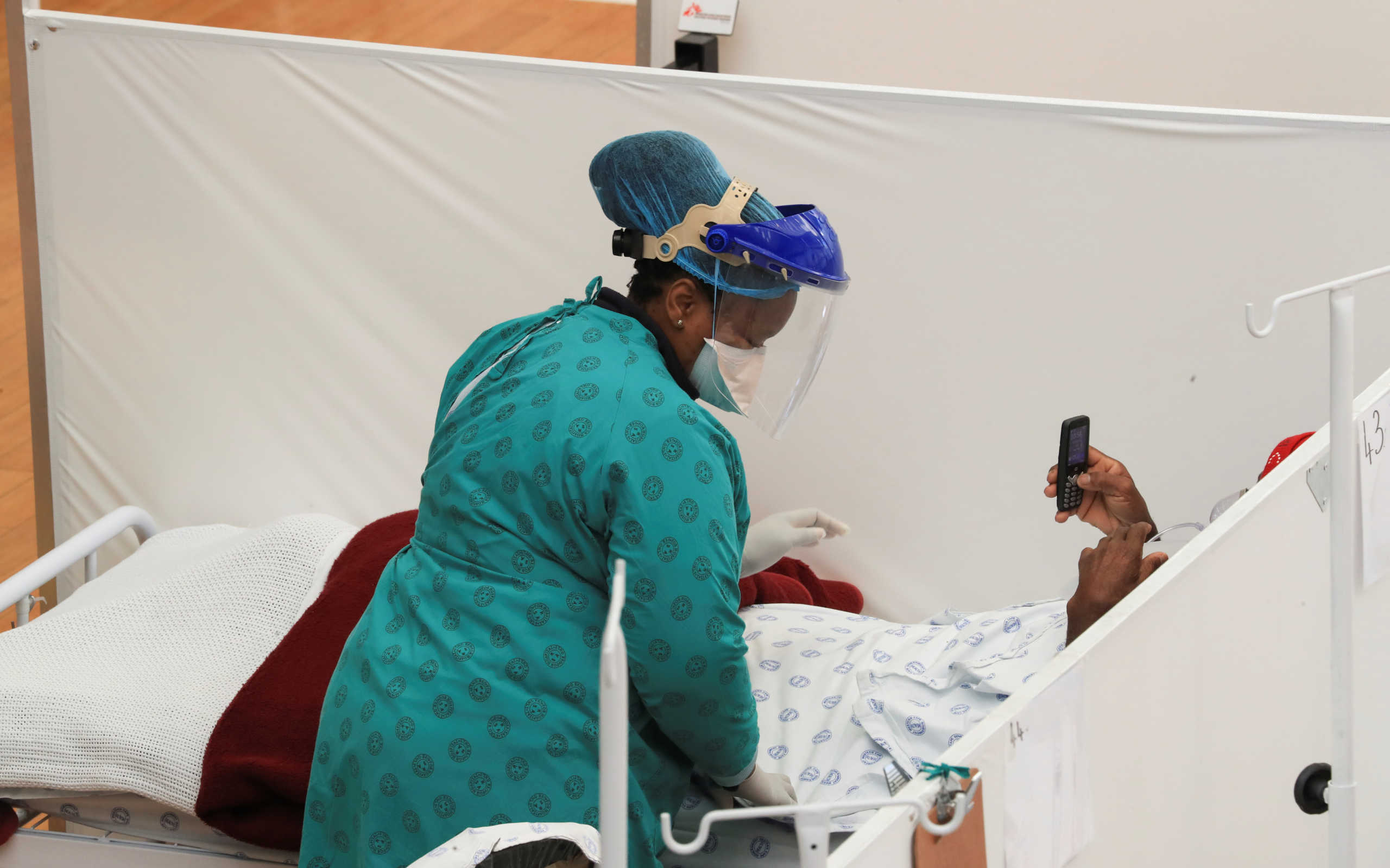 A health worker treats a patient at a temporary field hospital set up by Medecins Sans Frontieres (MSF) during the coronavirus disease (COVID-19) outbreak in Khayelitsha township near Cape Town, South Africa, July 21, 2020. REUTERS