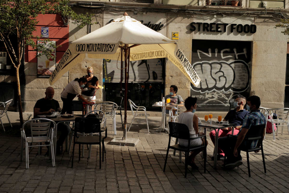 People sit on the terrace of a bar during the first day of mandatory use of protective masks everywhere regardless of social distancing in the Madrid region, amid the coronavirus disease (COVID-19) outbreak, in Madrid, Spain, July 30, 2020. REUTERS