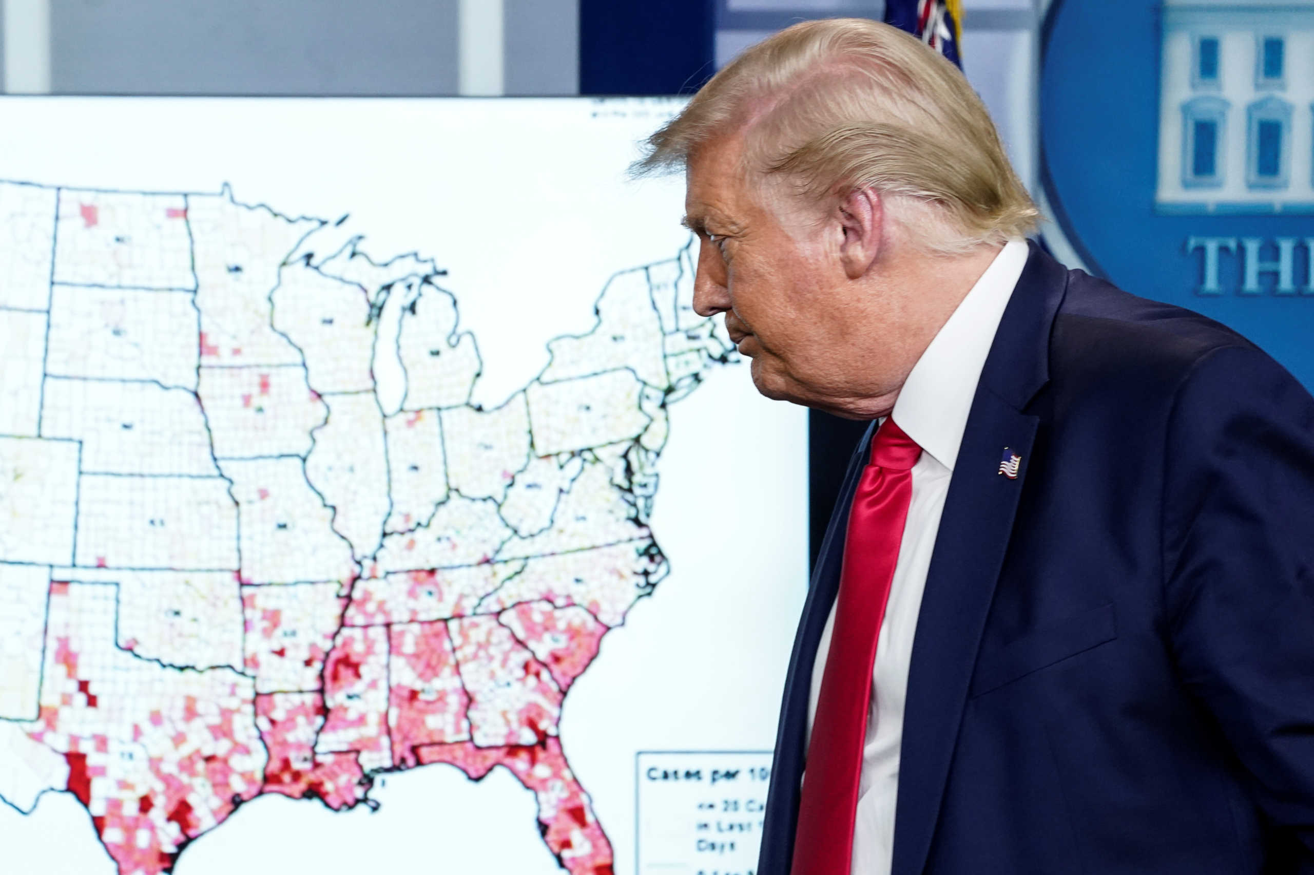 U.S. President Donald Trump walks past a U.S. map of reported coronavirus cases as he departs following a coronavirus disease (COVID-19) news briefing at the White House in Washington, U.S., July 23, 2020. REUTERS