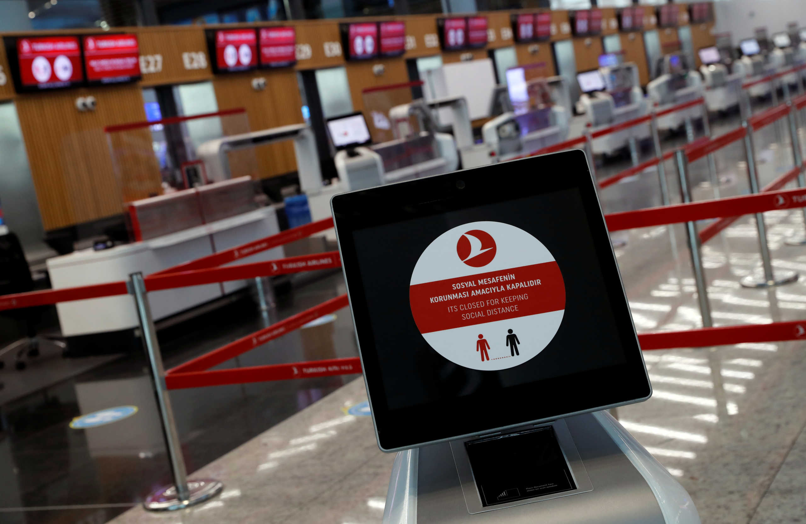 A social distancing sign is seen before the Turkish Airlines check-in counters at the international departure terminal of the Istanbul Airport amid the coronavirus disease (COVID-19) outbreak, in Istanbul, Turkey June 19, 2020. REUTERS