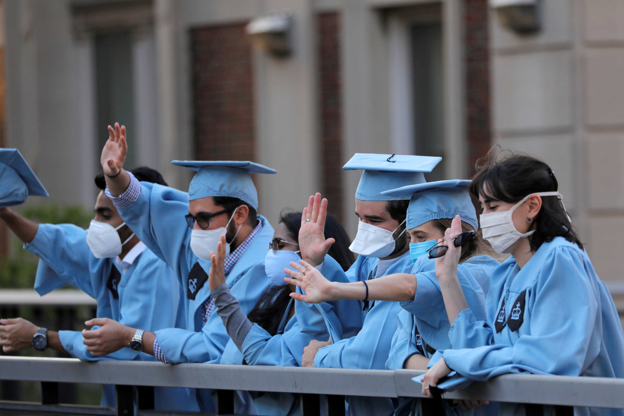 FILE PHOTO: Graduating Masters Students from the Columbia University Graduate School of Architecture, Planning and Preservation (GSAPP) wave to passing traffic from an overpass the day before their graduation ceremony, which is to be held online due to the outbreak of the coronavirus disease (COVID-19) in Manhattan, New York City, U.S., May 15, 2020. REUTERS