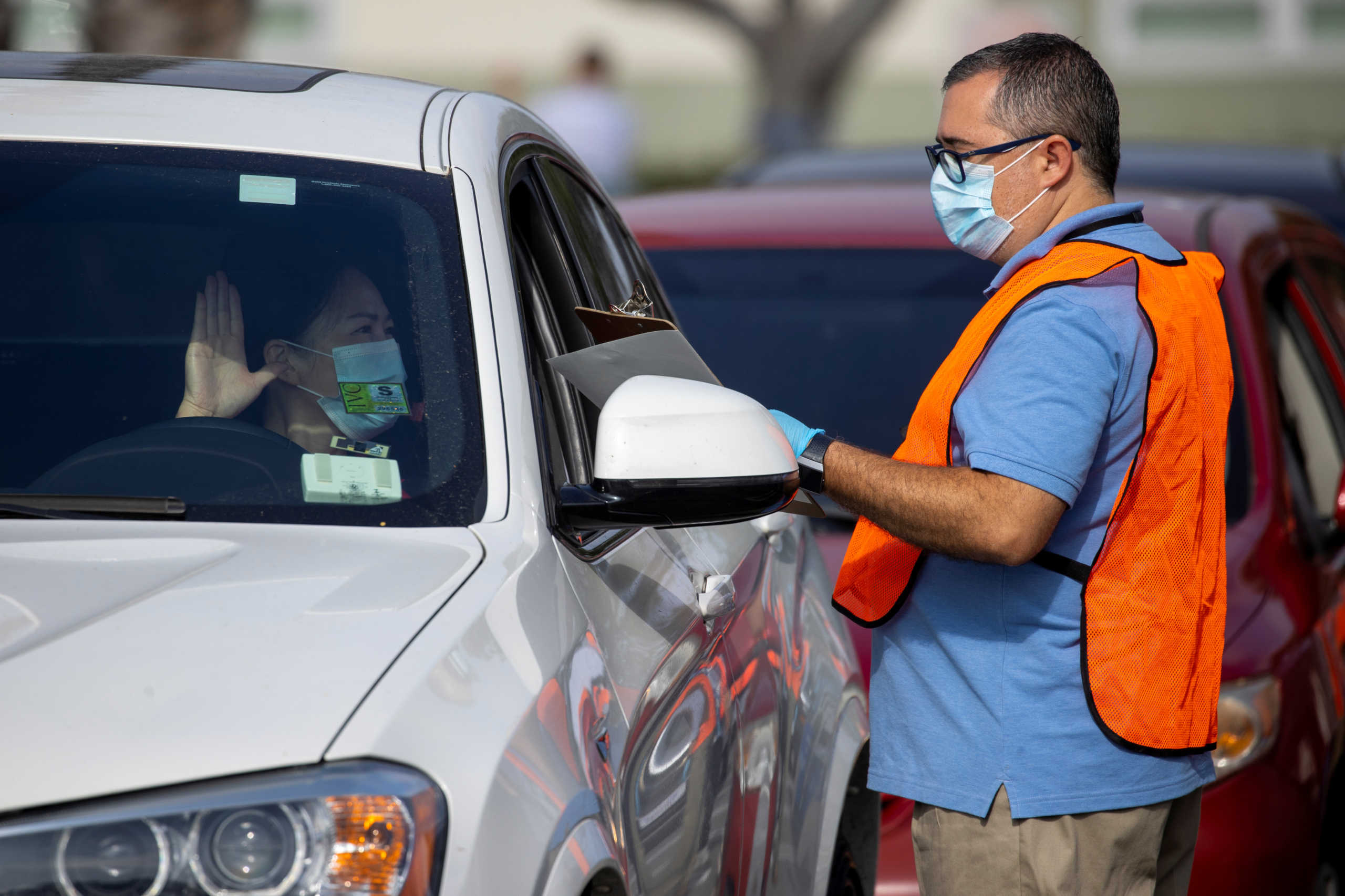A U.S. immigration officer administers the oath as a swearing-in of newly naturalized United States citizens takes place in an empty parking lot during the outbreak of the coronavirus disease (COVID-19) in Santa Ana, California, U.S., July 29, 2020.      REUTERS