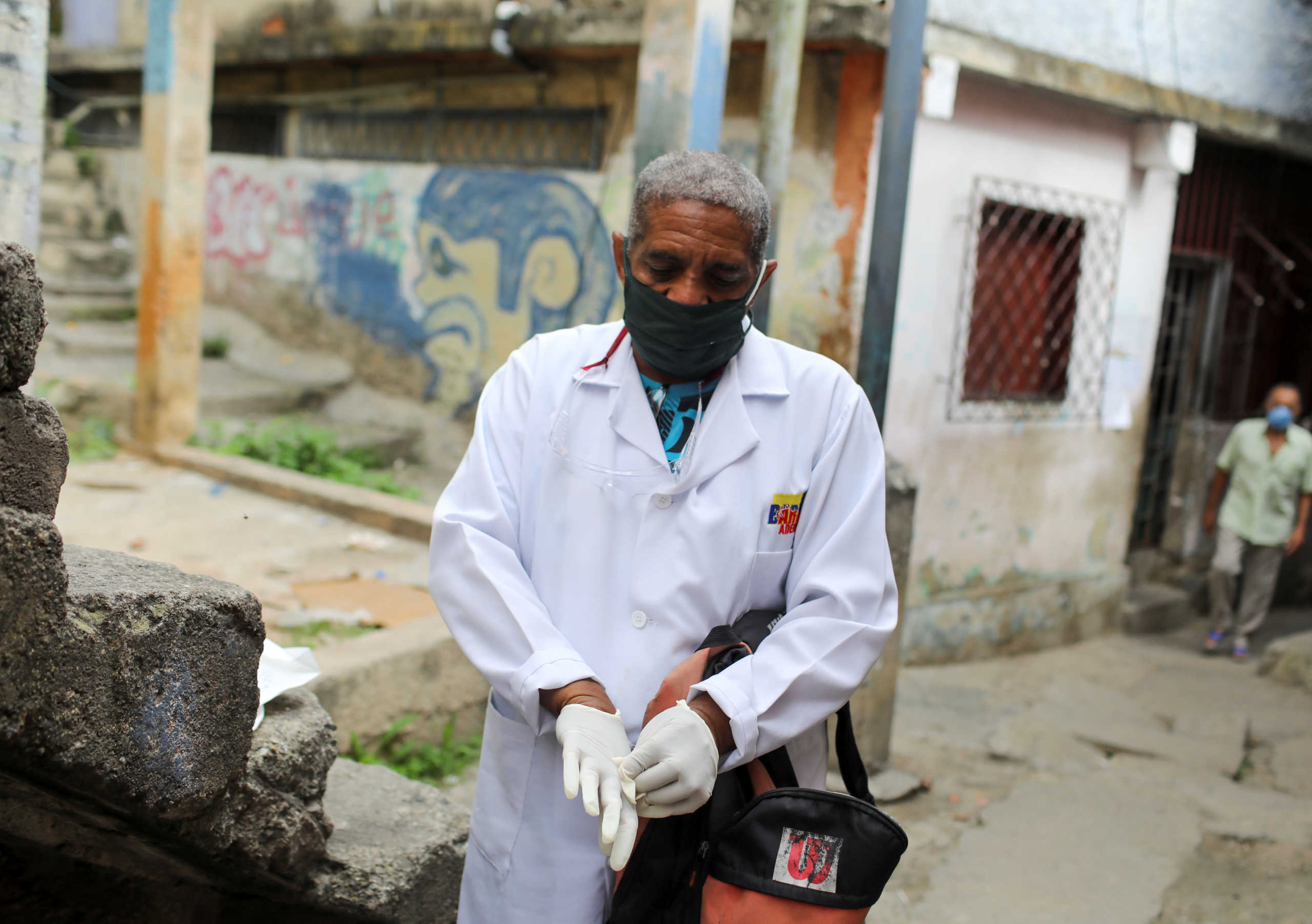A doctor puts on gloves during a walking round at the low-income neighborhood of Las Mayas, as cases rise amid the coronavirus disease (COVID-19) outbreak, in Caracas, Venezuela July 14, 2020. Picture taken July 14, 2020. REUTERS