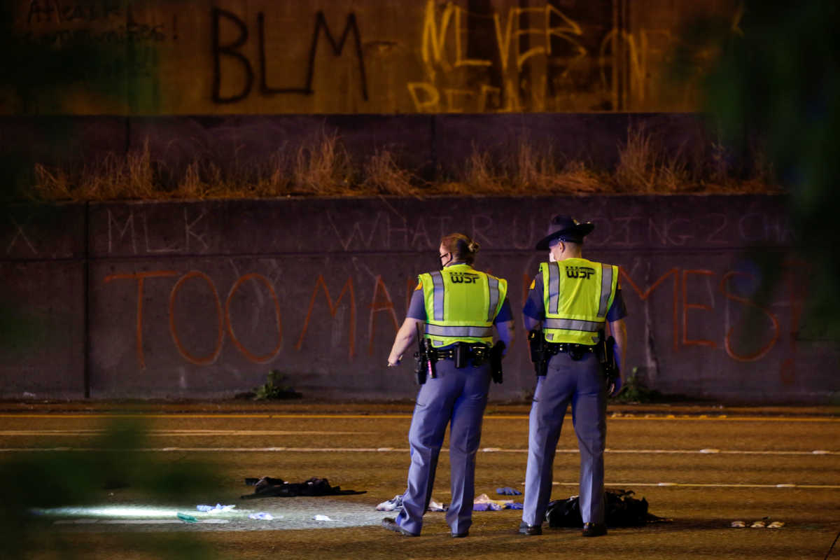 Washington State Troopers investigate the scene where two people in a group of protesters were stuck by a car on Interstate 5 while the highway was closed to traffic due to the protest in Seattle, Washington, U.S., July 4, 2020. REUTERS
