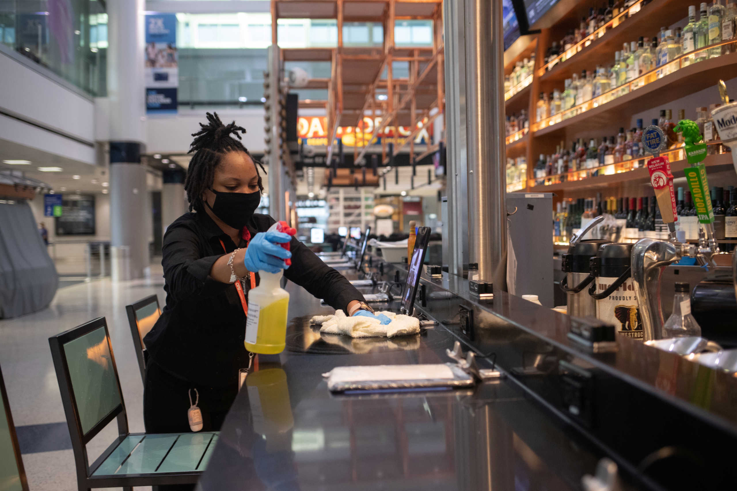 A woman cleans and disinfects a bar at a restaurant at Terminal E of IAH George Bush Intercontinental Airport amid the coronavirus disease (COVID-19) outbreak in Houston, Texas, U.S., July 21, 2020. REUTERS