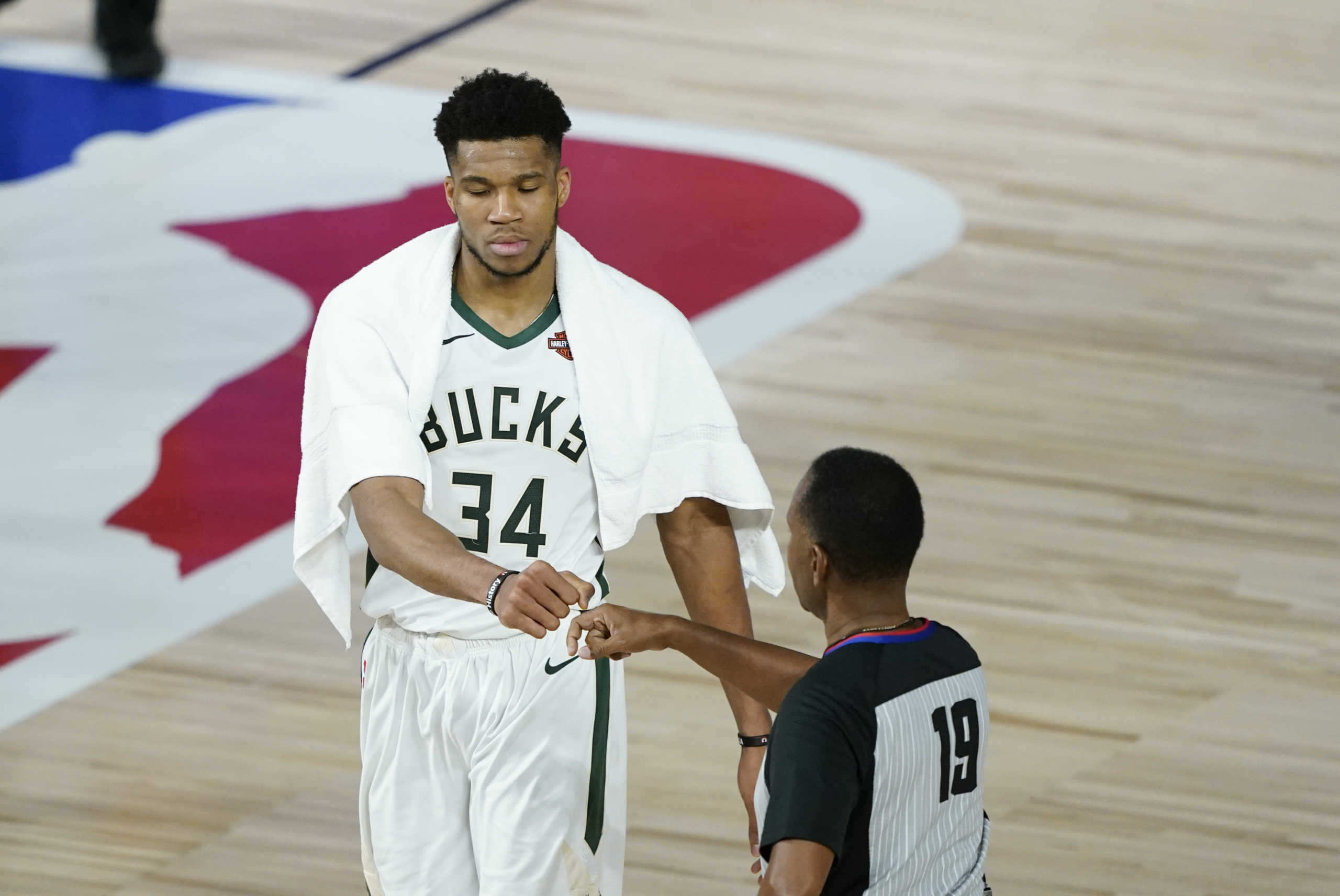 Aug 24, 2020; Lake Buena Vista, Florida, USA; Milwaukee Bucks' Giannis Antetokounmpo (34) fist bumps referee James Capers (19) after an NBA basketball first round playoff game against the Orlando Magic in game four of the first round of the 2020 NBA Playoffs at The Field House. Mandatory Credit: Ashley Landis

 Monday, Aug. 24, 2020, in Lake Buena Vista, Fla. (AP Photo