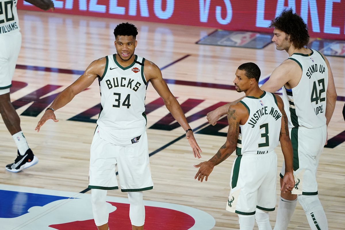 Aug 20, 2020; Lake Buena Vista, Florida, USA; Milwaukee Bucks forward Giannis Antetokounmpo (34) celebrates with guard George Hill (3) and center Robin Lopez (42) after defeating the Orlando Magic in game two of the first round of the 2020 NBA Playoffs at The Field House. Mandatory Credit: Ashley Landis