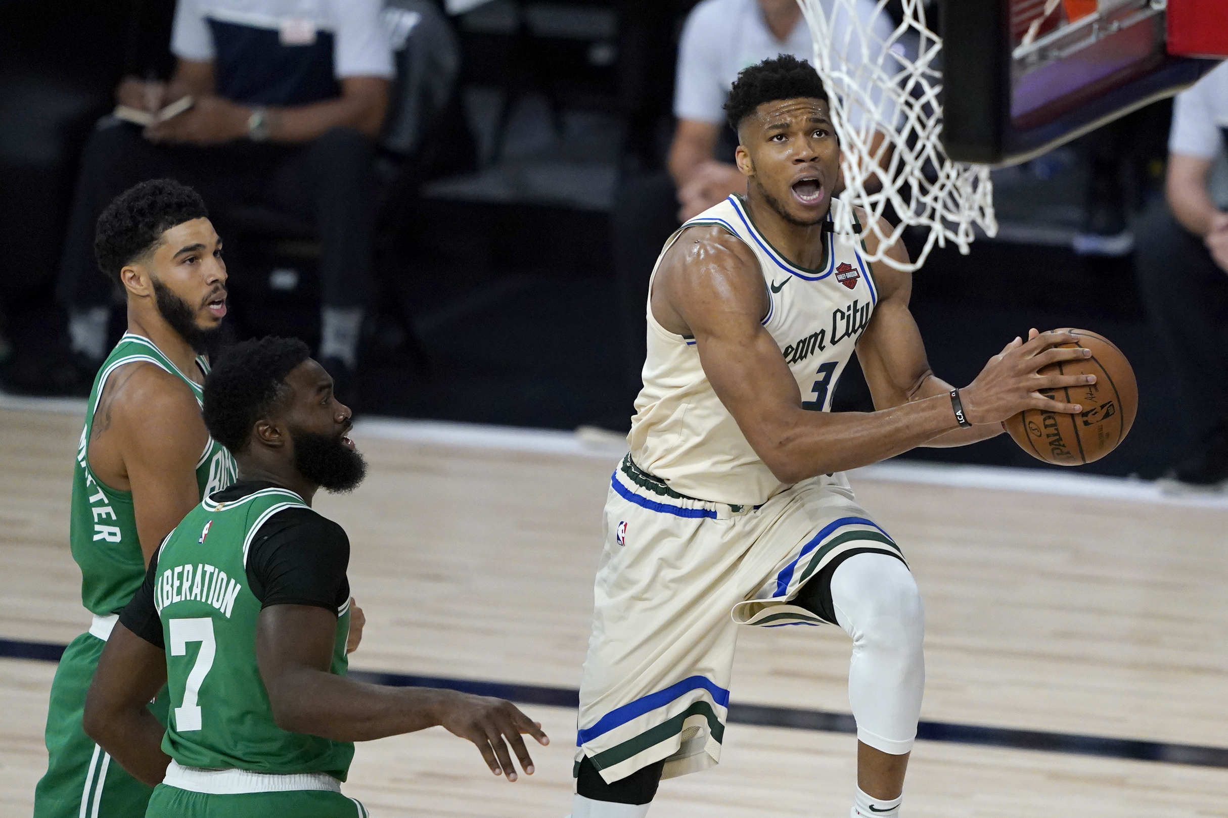 July 31, 2020; Lake Buena Vista, USA; Milwaukee Bucks' Giannis Antetokounmpo, right, heads to the basket past Boston Celtics' Jaylen Brown (7) during the first half of an NBA basketball game Friday, July 31, 2020, in Lake Buena Vista, Fla.  Mandatory Credit: Ashley Landis