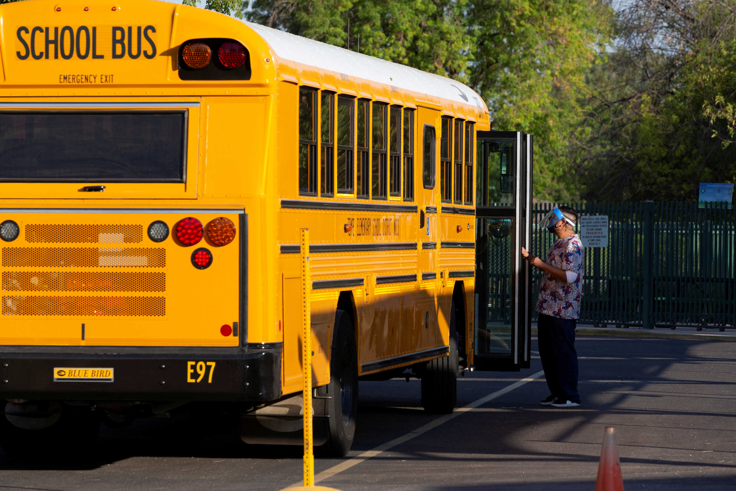 An employee waits to assist a student off a bus as in-person learning resumes with restrictions in place to prevent the spread of coronavirus disease (COVID-19) at Rover Elementary School in Tempe, Arizona, U.S., August 17, 2020.  REUTERS