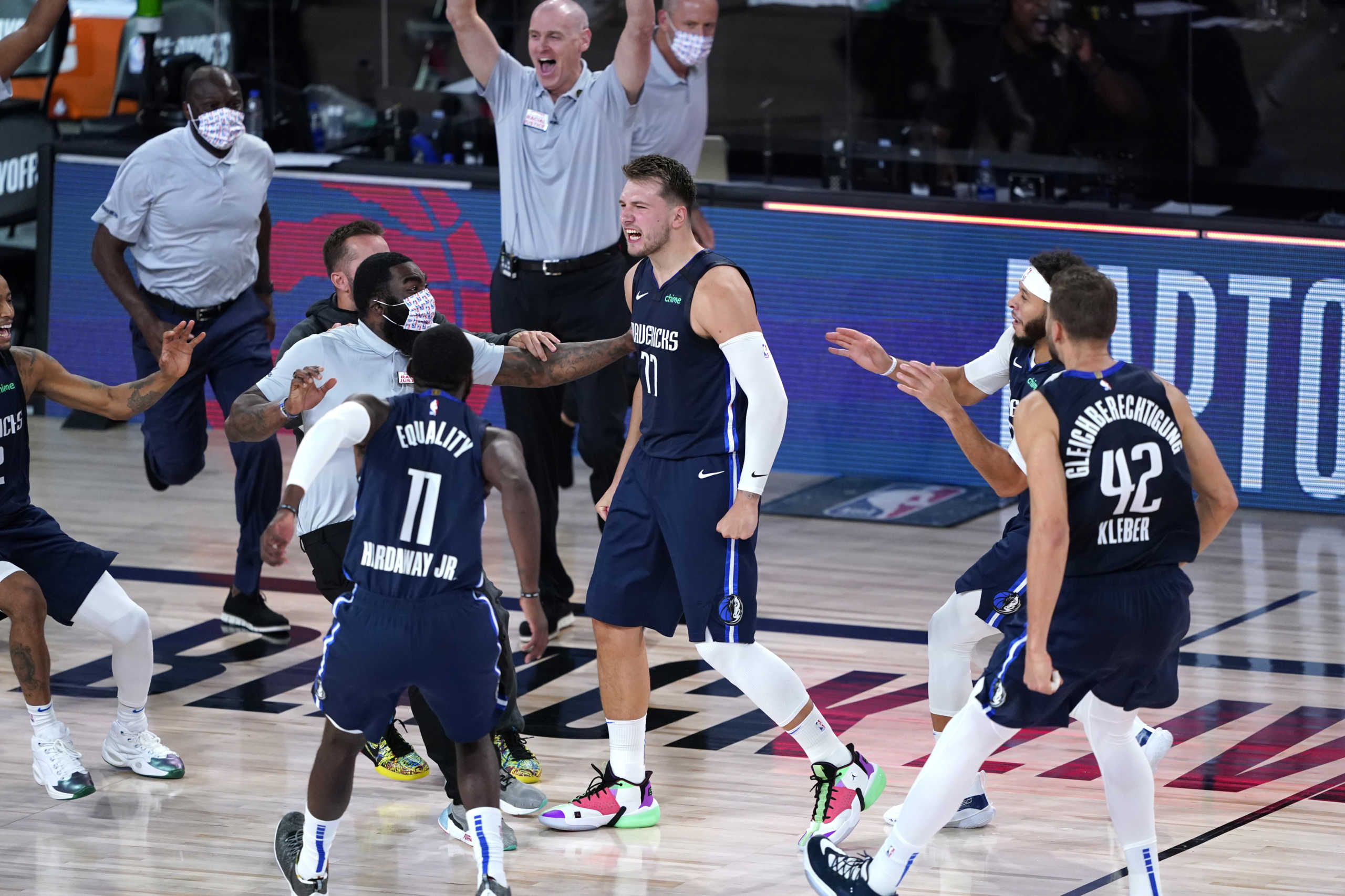 Aug 23, 2020; Lake Buena Vista, Florida, USA; Dallas Mavericks' Luka Doncic (77) celebrates with teammates after making a game-winning 3-point basket against the Los Angeles Clippers during overtime of an NBA basketball first round playoff game at AdventHealth Arena. Mandatory Credit: Ashley Landis