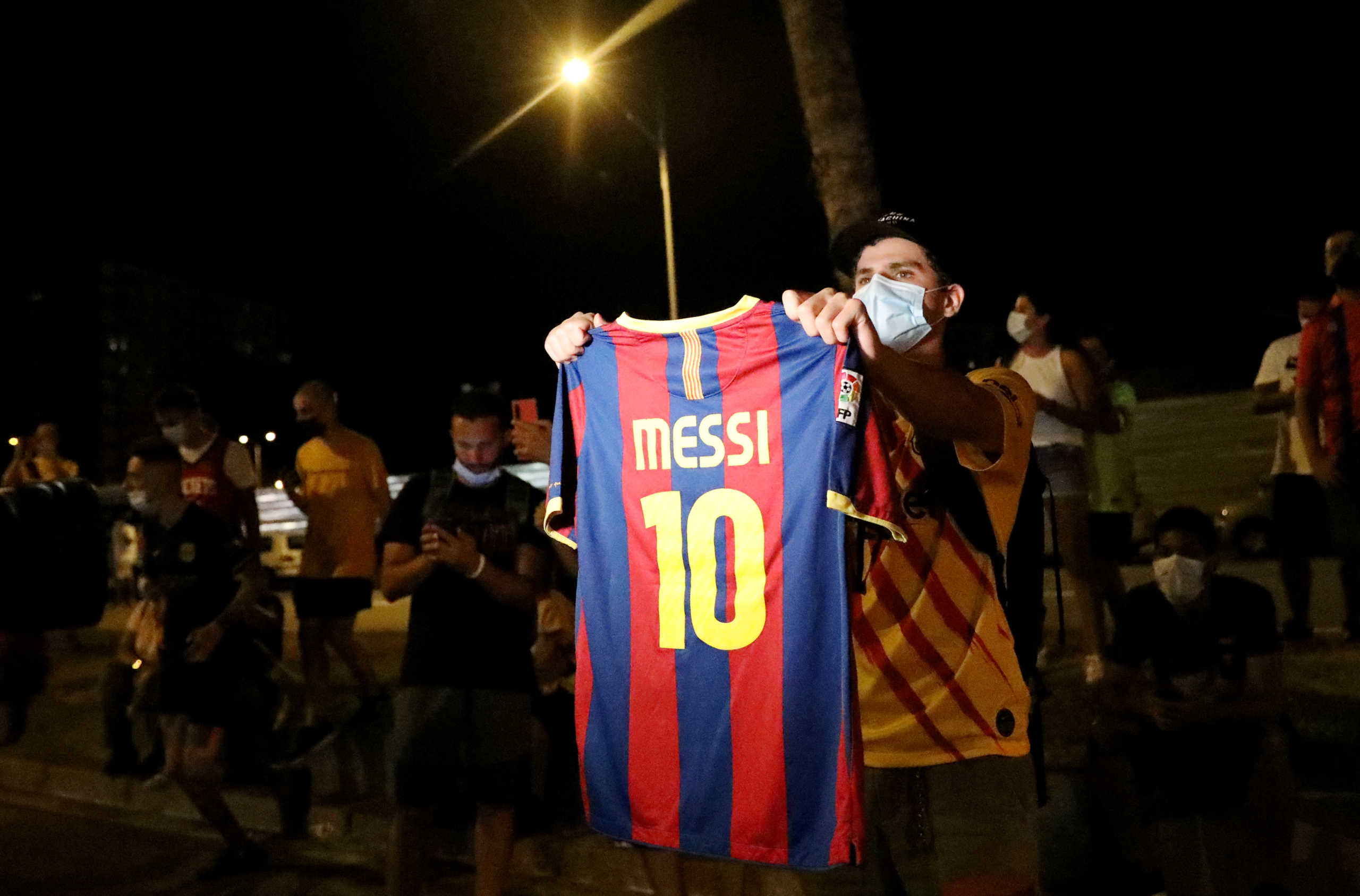 Soccer Football - Camp Nou, Barcelona, Spain - August 25, 2020   A Barcelona fan holds up a Lionel Messi shirt outside the Camp Nou after captain Lionel Messi told Barcelona he wishes to leave the club immediately, a source confirmed on Tuesday   REUTERS