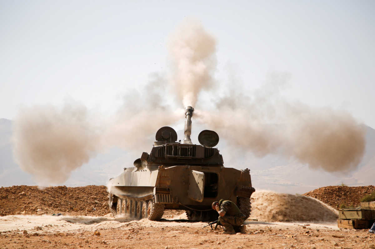 FILE PHOTO: A Hezbollah fighter reacts as he fires a weapon in Western Qalamoun, Syria August 23, 2017. REUTERS