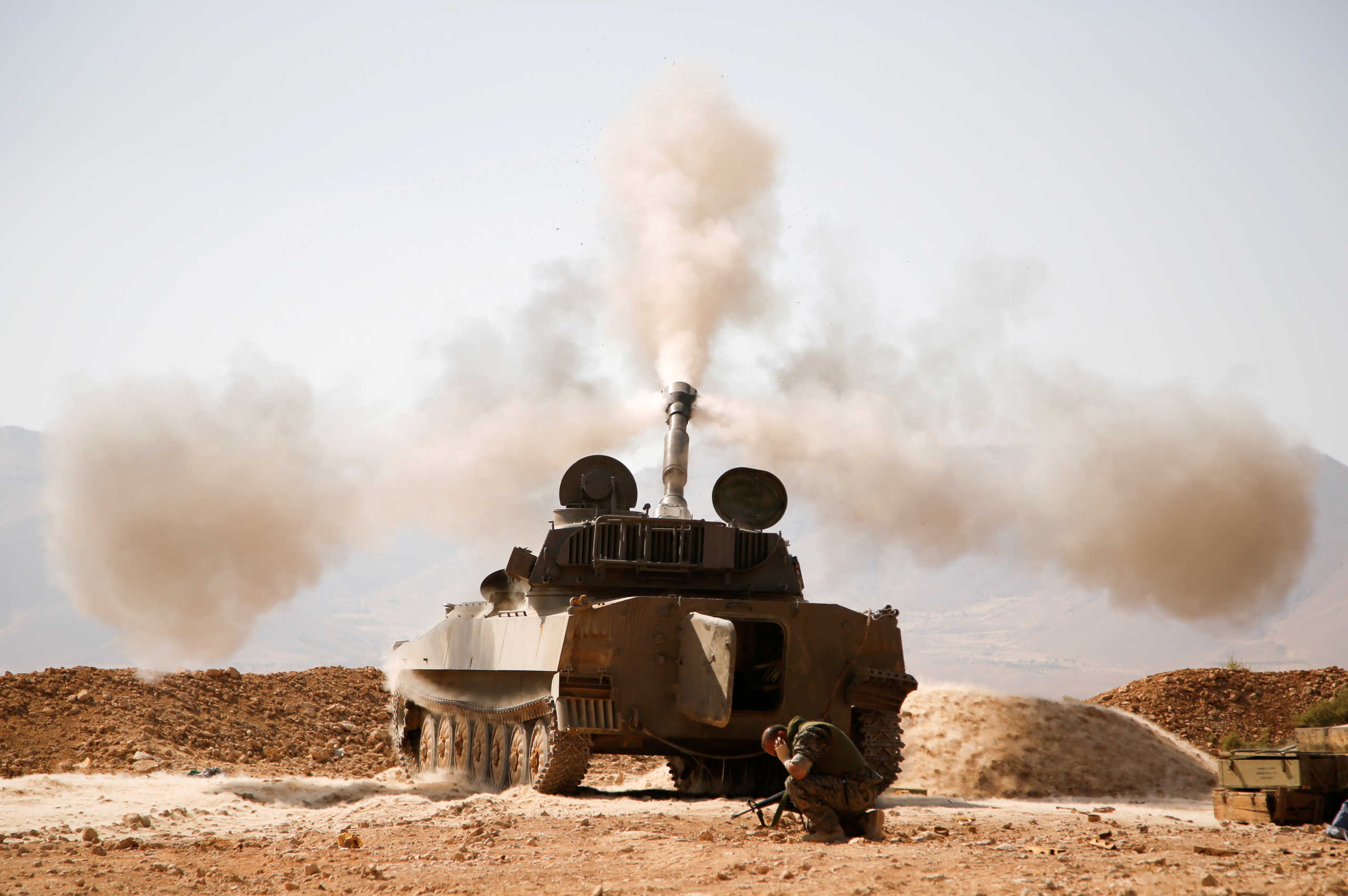 FILE PHOTO: A Hezbollah fighter reacts as he fires a weapon in Western Qalamoun, Syria August 23, 2017. REUTERS