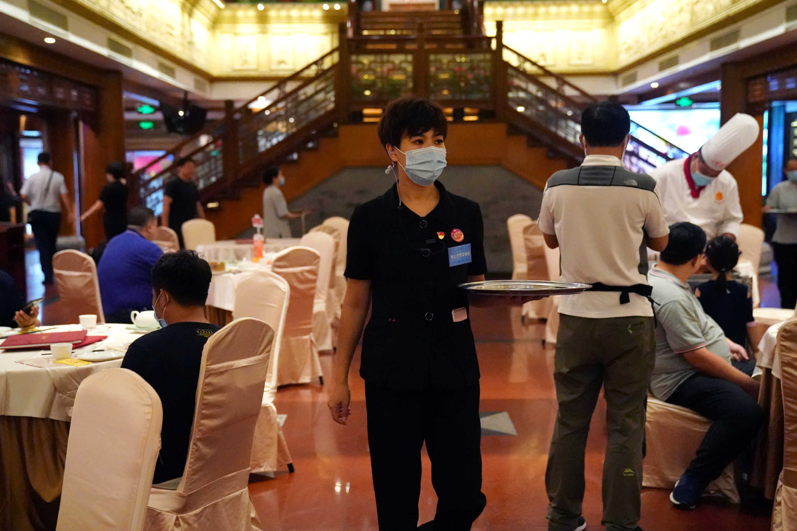 A staff member who is also an anti-food waste supervisor, holds a tray at the Quanjude Roast Duck restaurant, following the coronavirus disease (COVID-19) outbreak in Beijing, China August 18, 2020. REUTERS