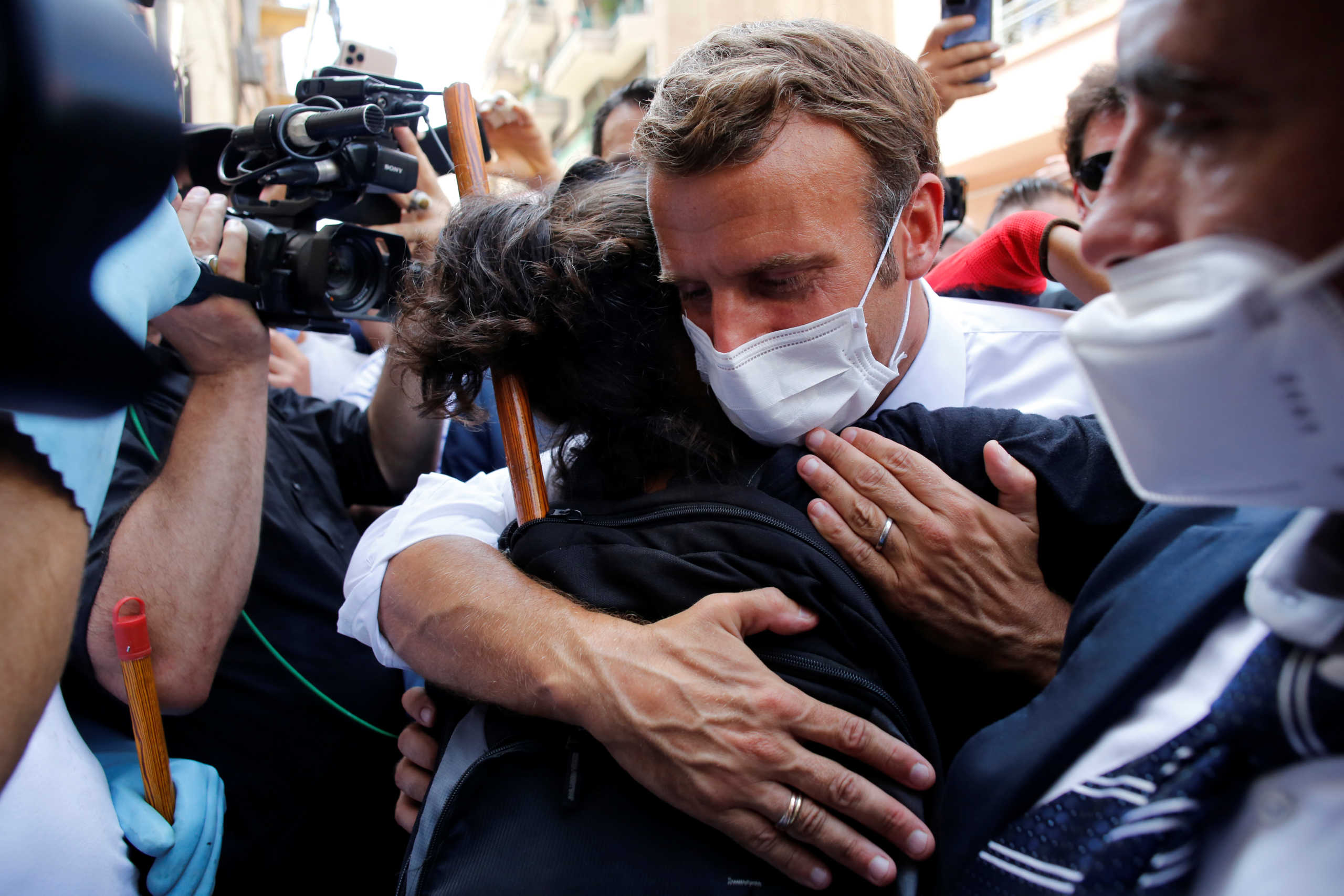 French President Emmanuel Macron hugs a resident as he visits a devastated street of Beirut, Lebanon August 6, 2020. Thibault Camus
