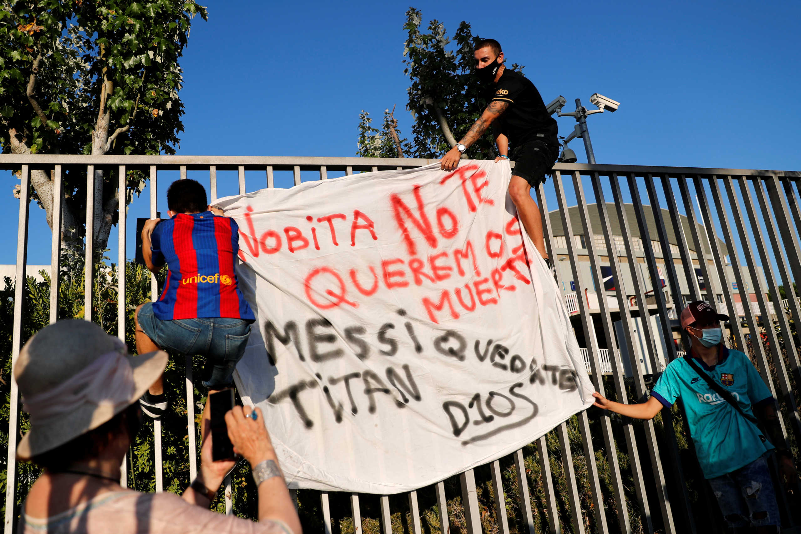 Soccer Football - Camp Nou, Barcelona, Spain - August 26, 2020   Fans of Barcelona hang a banner on a fence during a protest outside the Camp Nou after captain Lionel Messi told Barcelona he wishes to leave the club immediately   REUTERS