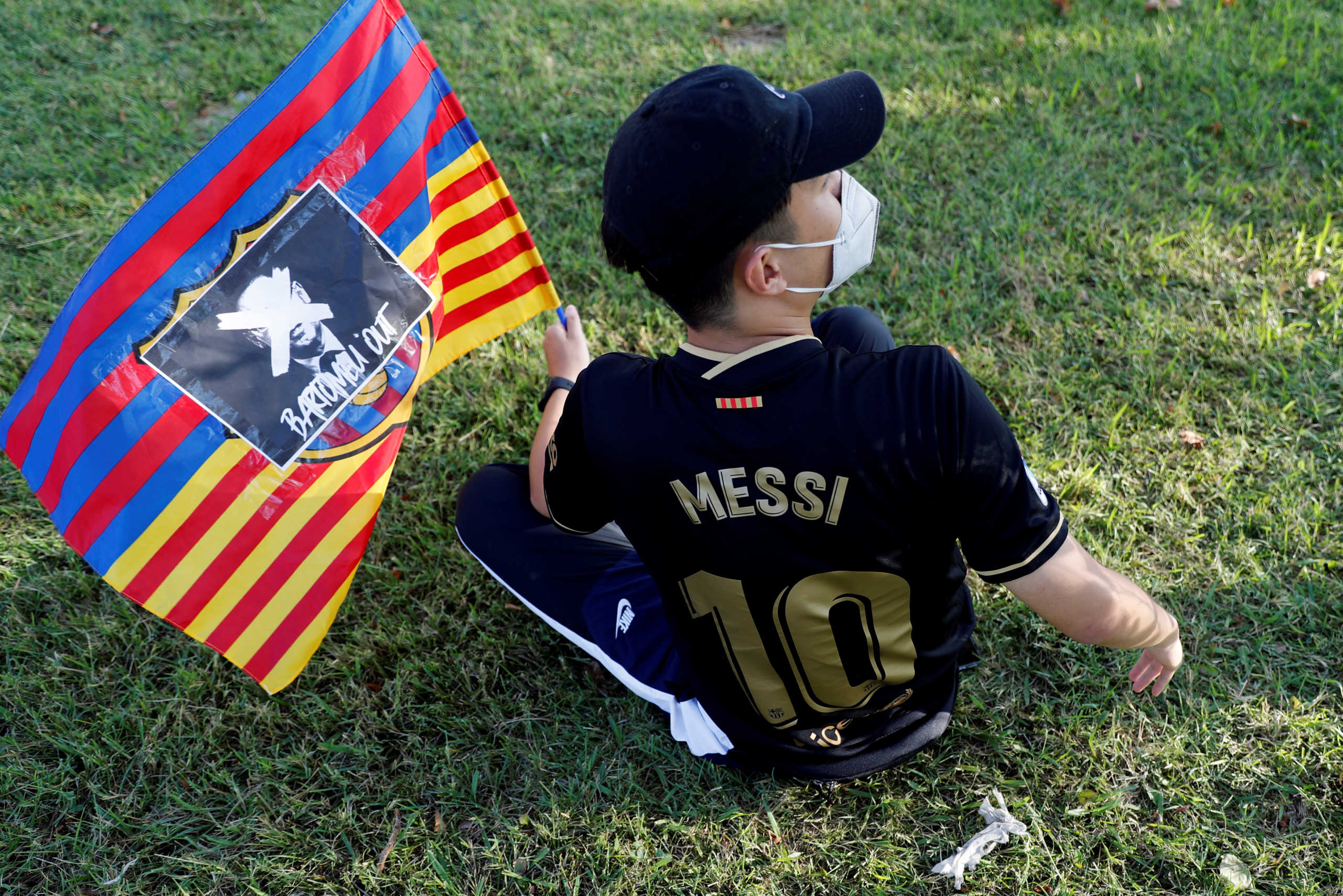 Soccer Football - Camp Nou, Barcelona, Spain - August 26, 2020   A Barcelona fan holds a flag with an image of Barcelona president Josep Maria Bartomeu on as fans protest outside the Camp Nou after captain Lionel Messi told Barcelona he wishes to leave the club immediately   REUTERS