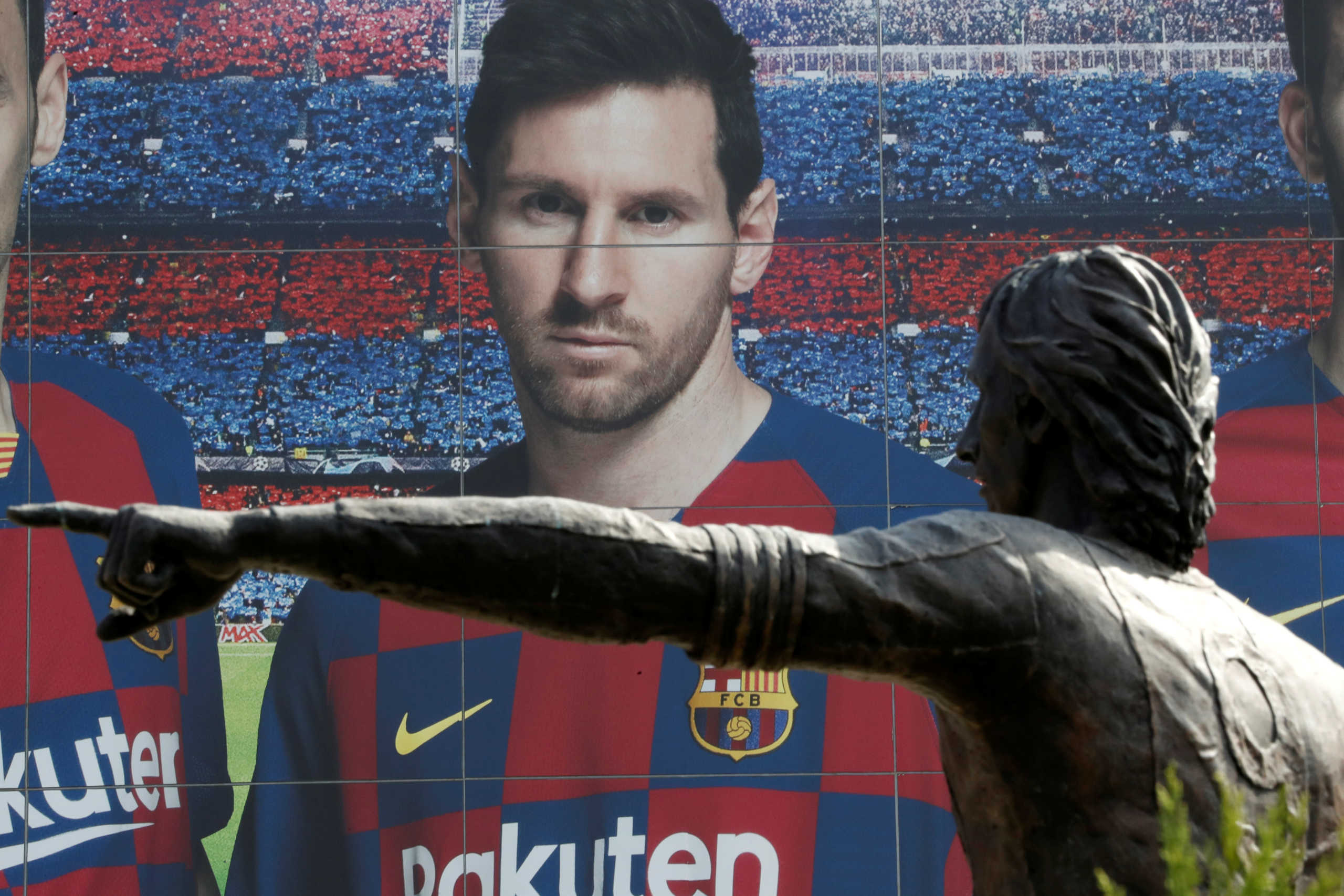 Soccer Football - Camp Nou, Barcelona, Spain - August 26, 2020   A statue of Johan Cruyff is seen infront of an image of Lionel Messi outside the Camp Nou after captain Lionel Messi told Barcelona he wishes to leave the club immediately, a source confirmed on Tuesday   REUTERS