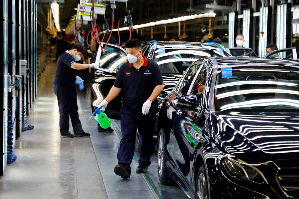FILE PHOTO: Employees wearing face masks work at a plant of Daimler-BAIC joint venture’s Beijing Benz Automotive Co during a government organised tour of the facility following the outbreak of the new coronavirus disease (COVID-19), in Beijing, China May 13, 2020. REUTERS