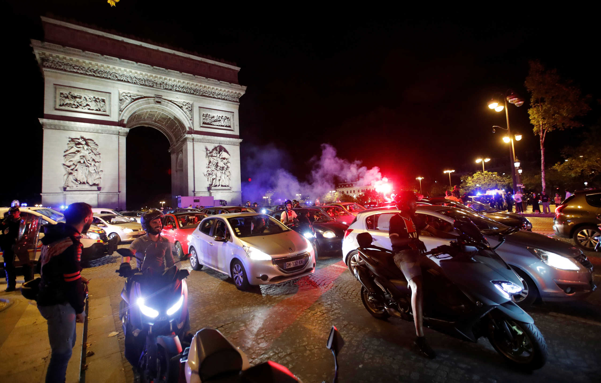 Soccer Football - Champions League - Semi Final - Paris St Germain fans celebrate after their Champions League Semi Final match against RB Leipzig - Paris, France - August 18, 2020  Paris St Germain fans celebrate in front of the Arc de Triomphe after the match  REUTERS