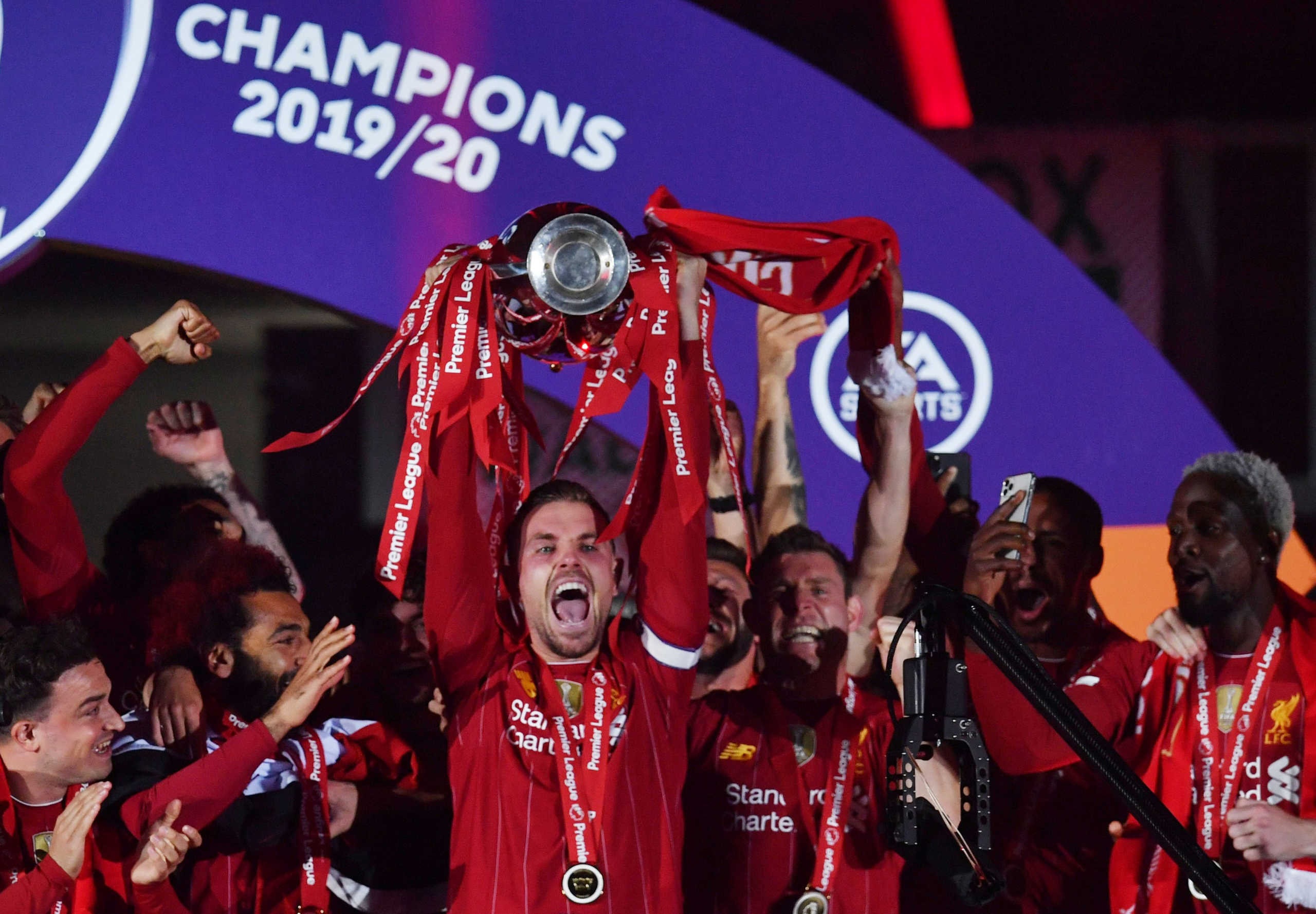 FILE PHOTO: Soccer Football - Premier League - Liverpool v Chelsea - Anfield, Liverpool, Britain - July 22, 2020 Liverpool's Jordan Henderson with team mates celebrates with the trophy after winning the Premier League Pool via REUTERS