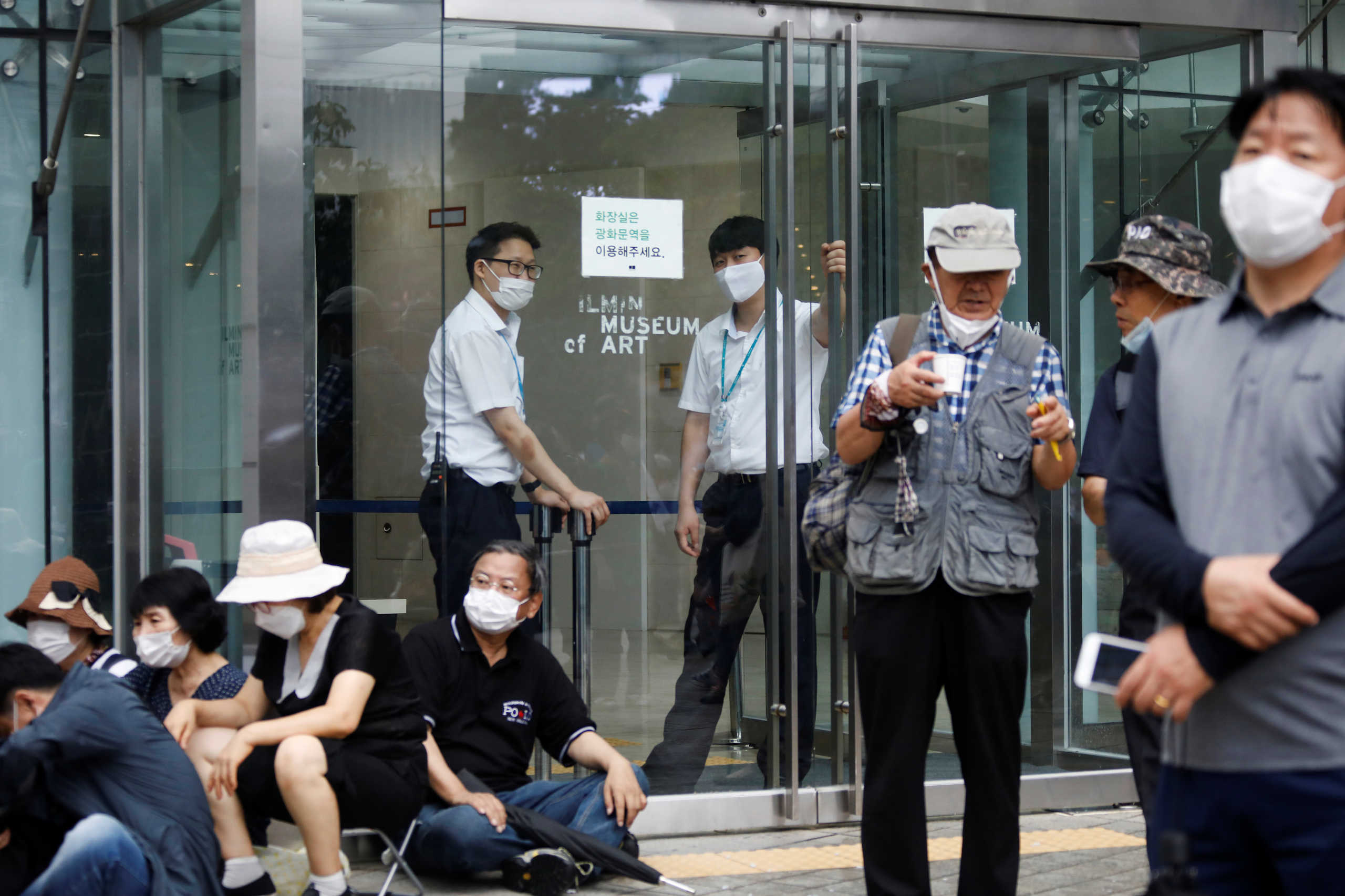 Security personnel stand at an entrance surrounded by members of conservative civic groups taking part in an anti-government protest, as concerns over a fresh wave of the coronavirus disease (COVID-19) cases grow, in central Seoul, South Korea, August 15, 2020.    REUTERS