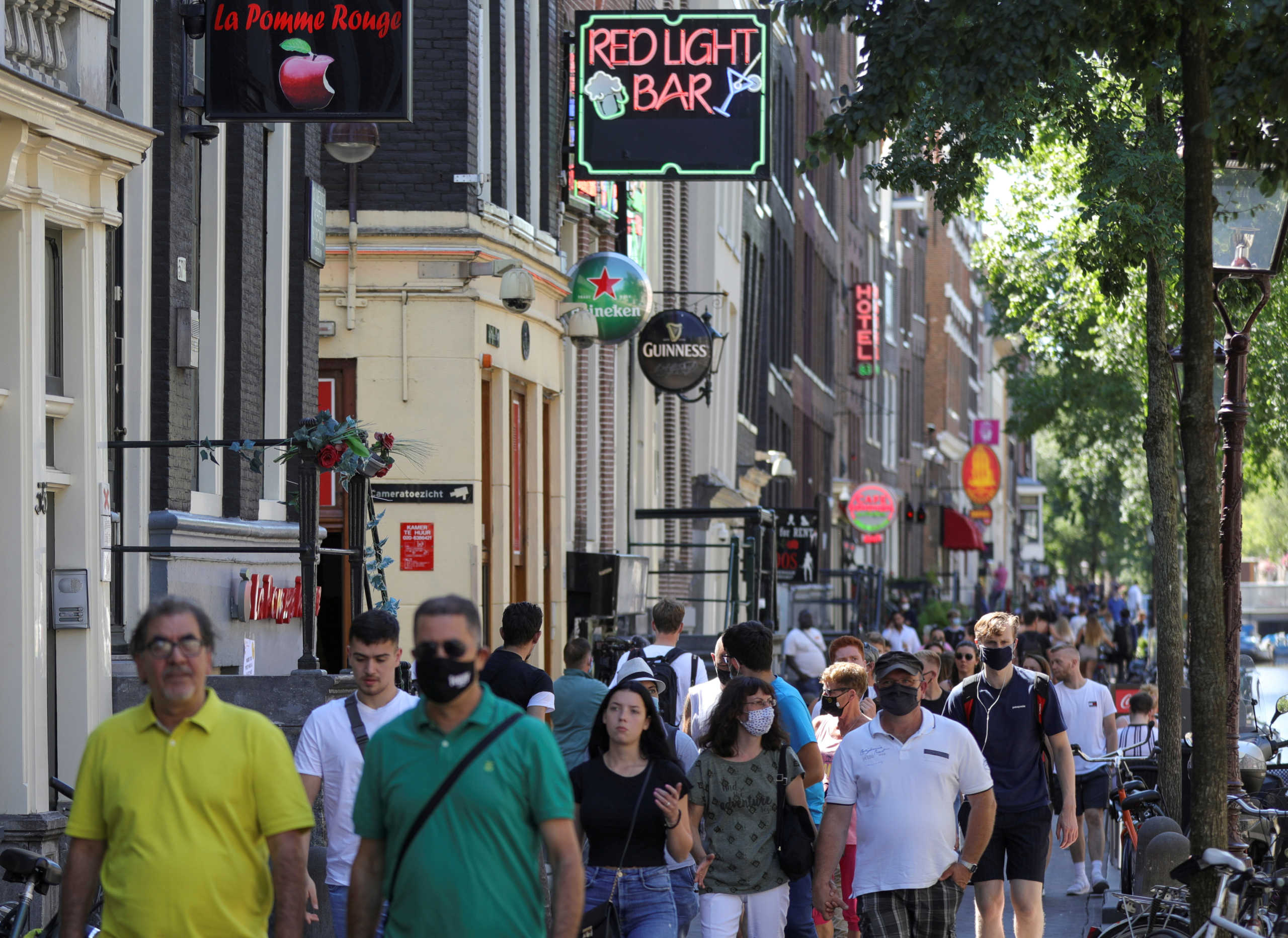 FILE PHOTO: People with and without masks in the Red Light District in Amsterdam, Netherlands August 5, 2020. REUTERS
