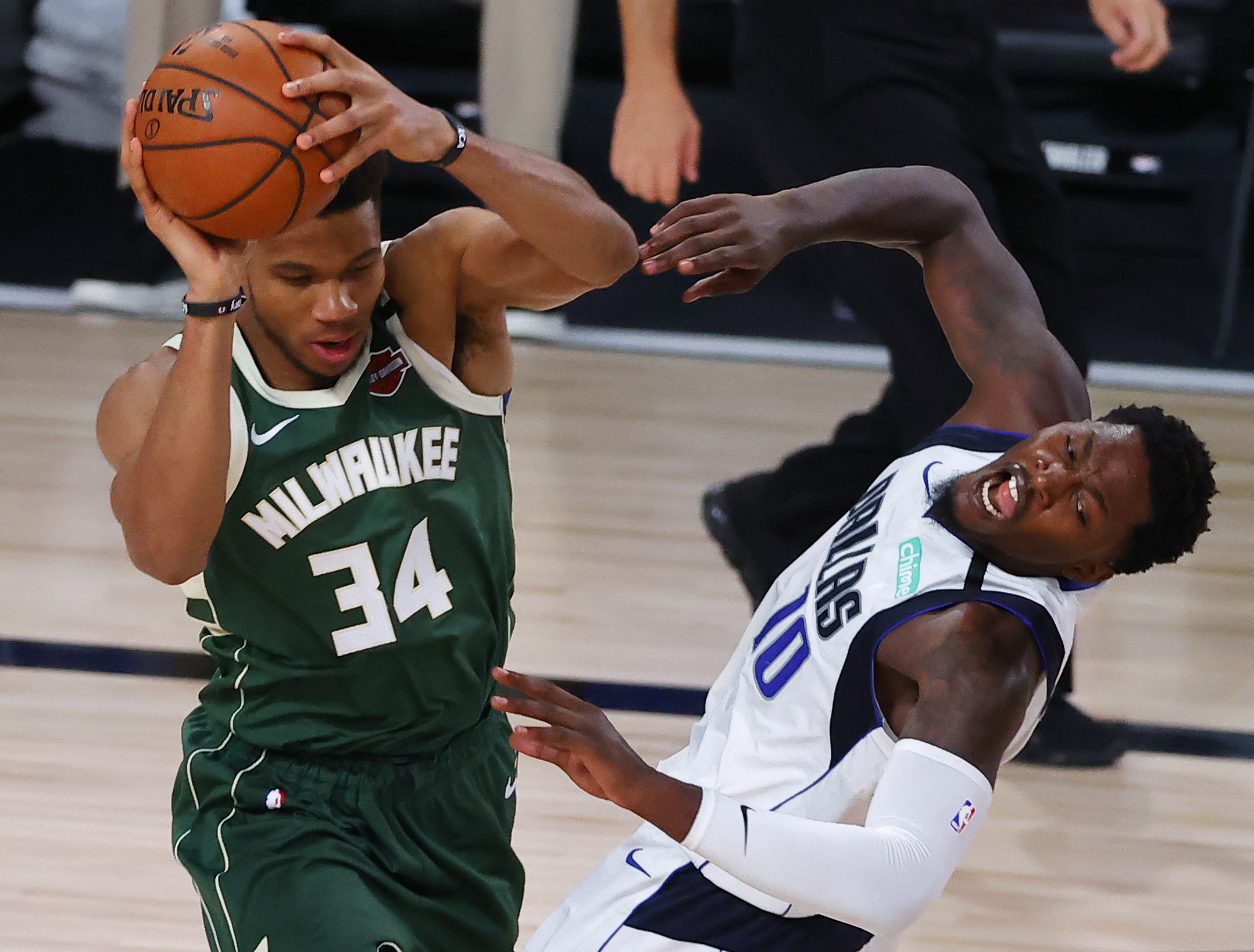 Aug 8, 2020; Lake Buena Vista, Florida, USA; Giannis Antetokounmpo #34 of the Milwaukee Bucks collides with Dorian Finney-Smith #10 of the Dallas Maverick at AdventHealth Arena. Mandatory Credit: Kevin C. Cox
