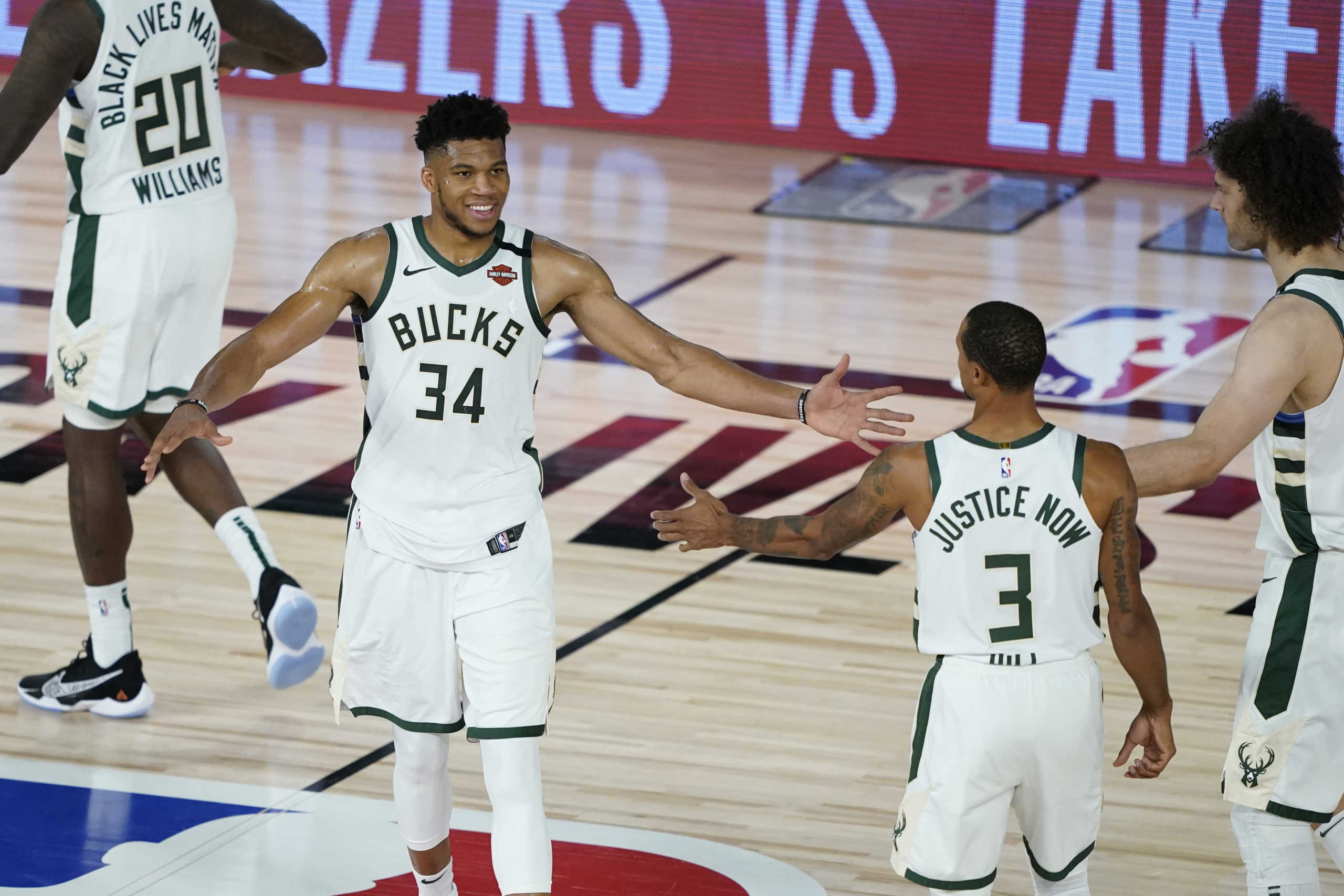 Aug 20, 2020; Lake Buena Vista, Florida, USA; Milwaukee Bucks forward Giannis Antetokounmpo (34) celebrates with guard George Hill (3) and center Robin Lopez (42) after defeating the Orlando Magic in game two of the first round of the 2020 NBA Playoffs at The Field House. Mandatory Credit: Ashley Landis