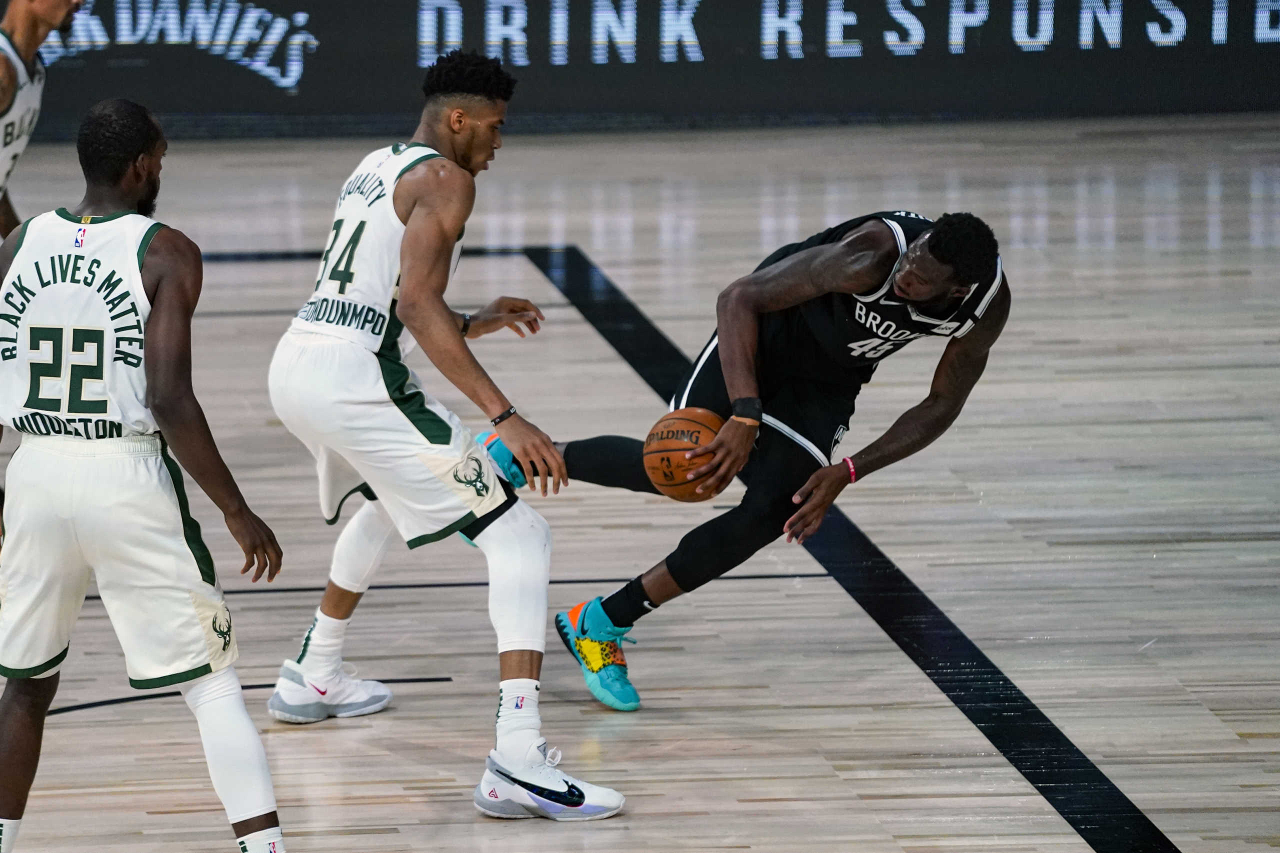 Aug 4, 2020; Lake Buena Vista, USA;  Brooklyn Nets forward Donta Hall (right) tries to save the ball in front of Milwaukee Bucks forward Giannis Antetokounmpo (34) during the first half of an NBA basketball game Tuesday, Aug. 4, 2020 in Lake Buena Vista, Fla. Mandatory Credit: Ashley Landis