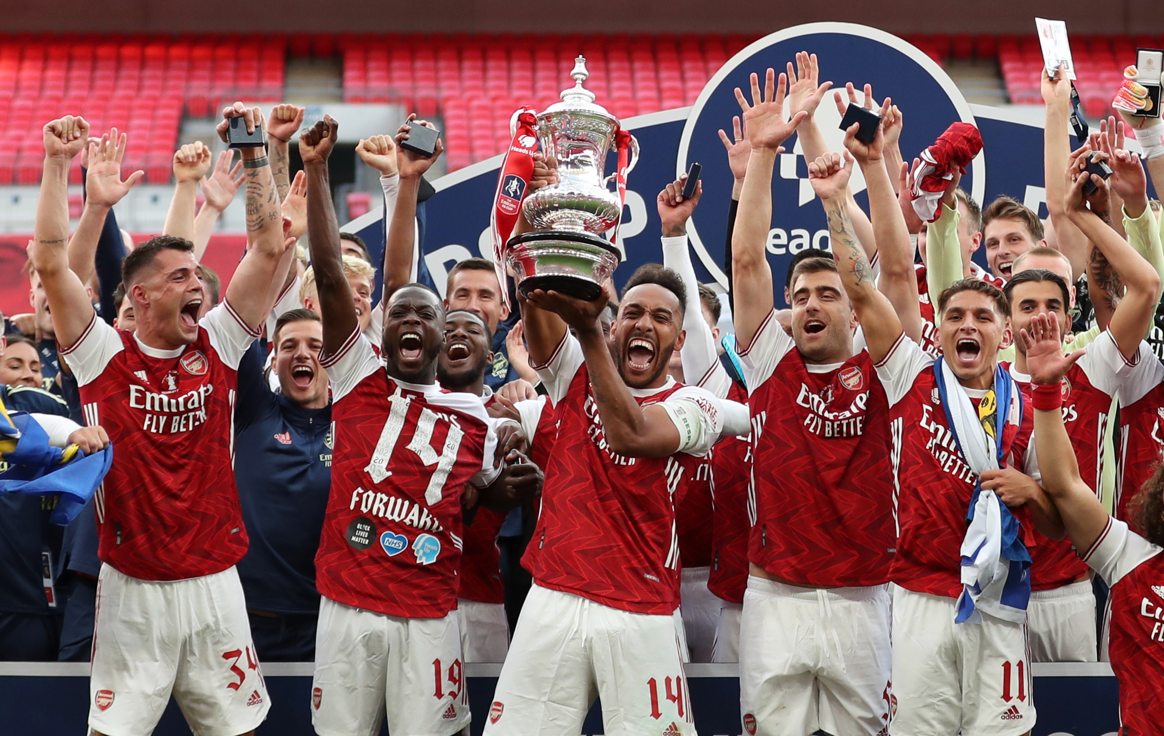 Soccer Football - FA Cup Final - Arsenal v Chelsea - Wembley Stadium, London, Britain - August 1, 2020 Arsenal's Pierre-Emerick Aubameyang celebrates with the trophy and teammates after winning the FA Cup, as play resumes behind closed doors following the outbreak of the coronavirus disease (COVID-19) Pool via REUTERS