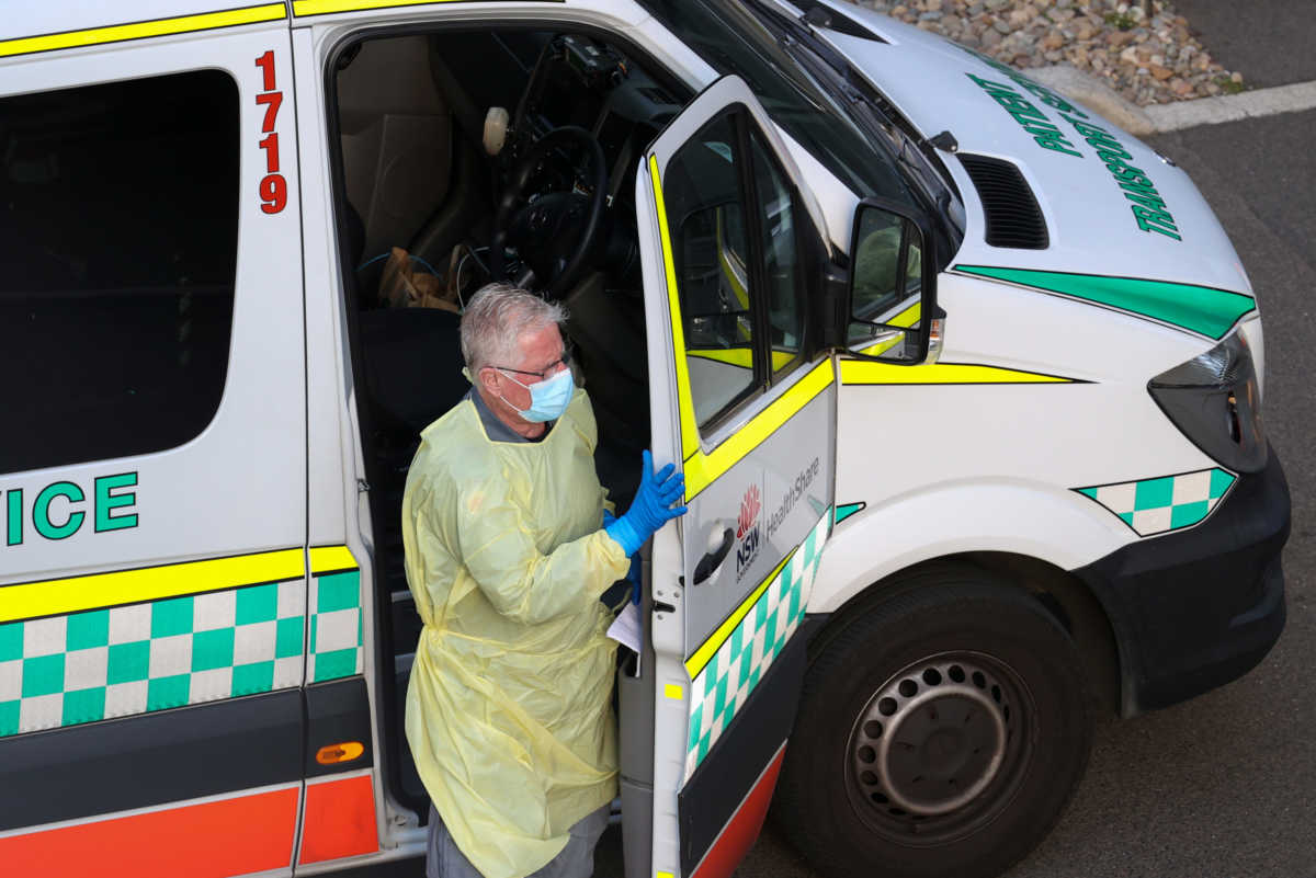 A driver steps out of a patient transport service vehicle outside a quarantine hotel, where returning travelers are kept in isolation for a period to curb the spread of the coronavirus disease (COVID-19), in Sydney, Australia, August 21, 2020.  REUTERS
