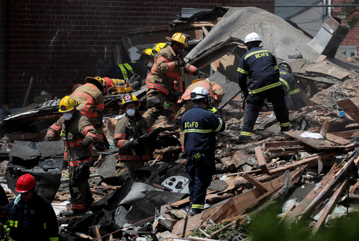 Fire fighters look for survivors at the scene of an explosion in a residential area of Baltimore, Maryland, U.S., August 10, 2020.  REUTERS