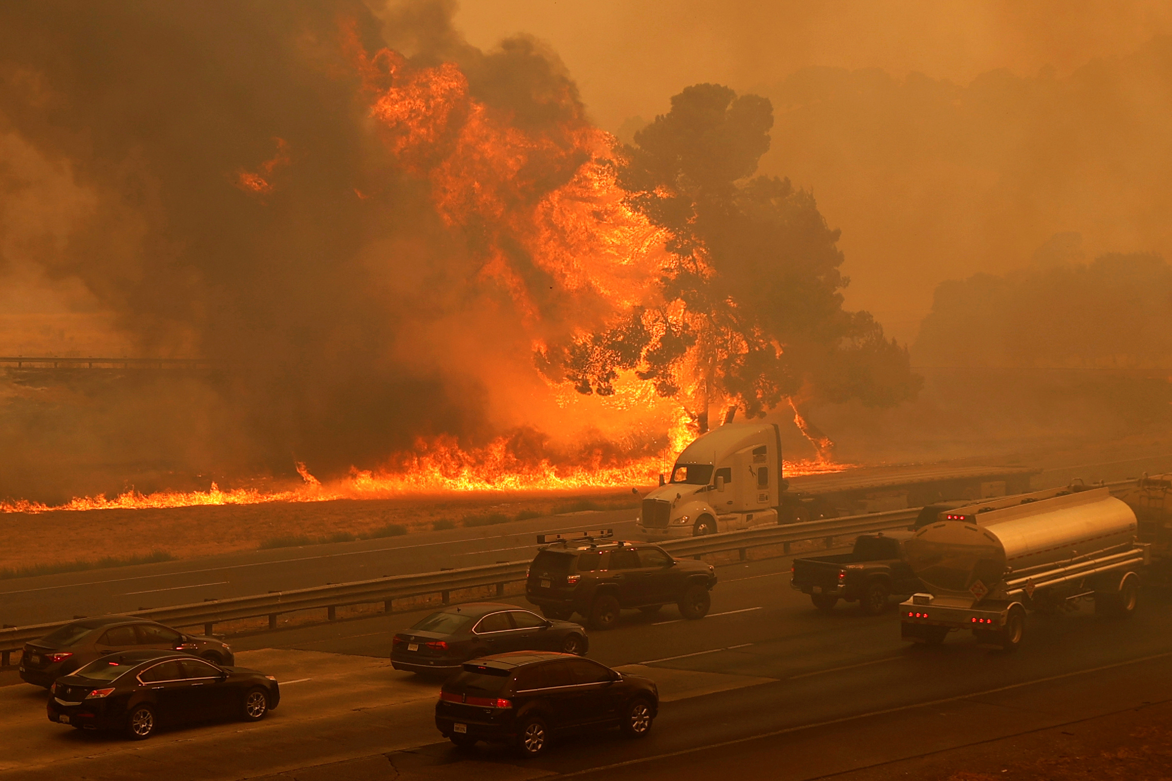 Vehicles are seen along Interstate 80 as flames from the LNU Lighting Complex Fire are seen on both sides on the outskirts of Vacaville, California, U.S. August 19, 2020. Picture taken August 19, 2020. REUTERS