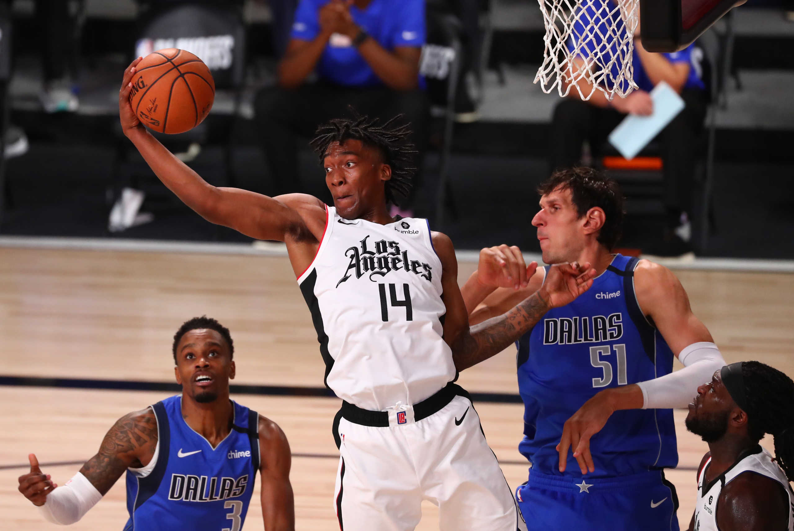 Aug 25, 2020; Lake Buena Vista, Florida, USA; LA Clippers guard Terance Mann (14) grabs a rebound against Dallas Mavericks center Boban Marjanovic (51) in the second half in game five of the first round of the 2020 NBA Playoffs at ESPN Wide World of Sports Complex. Mandatory Credit: Kim Klement-USA TODAY Sports