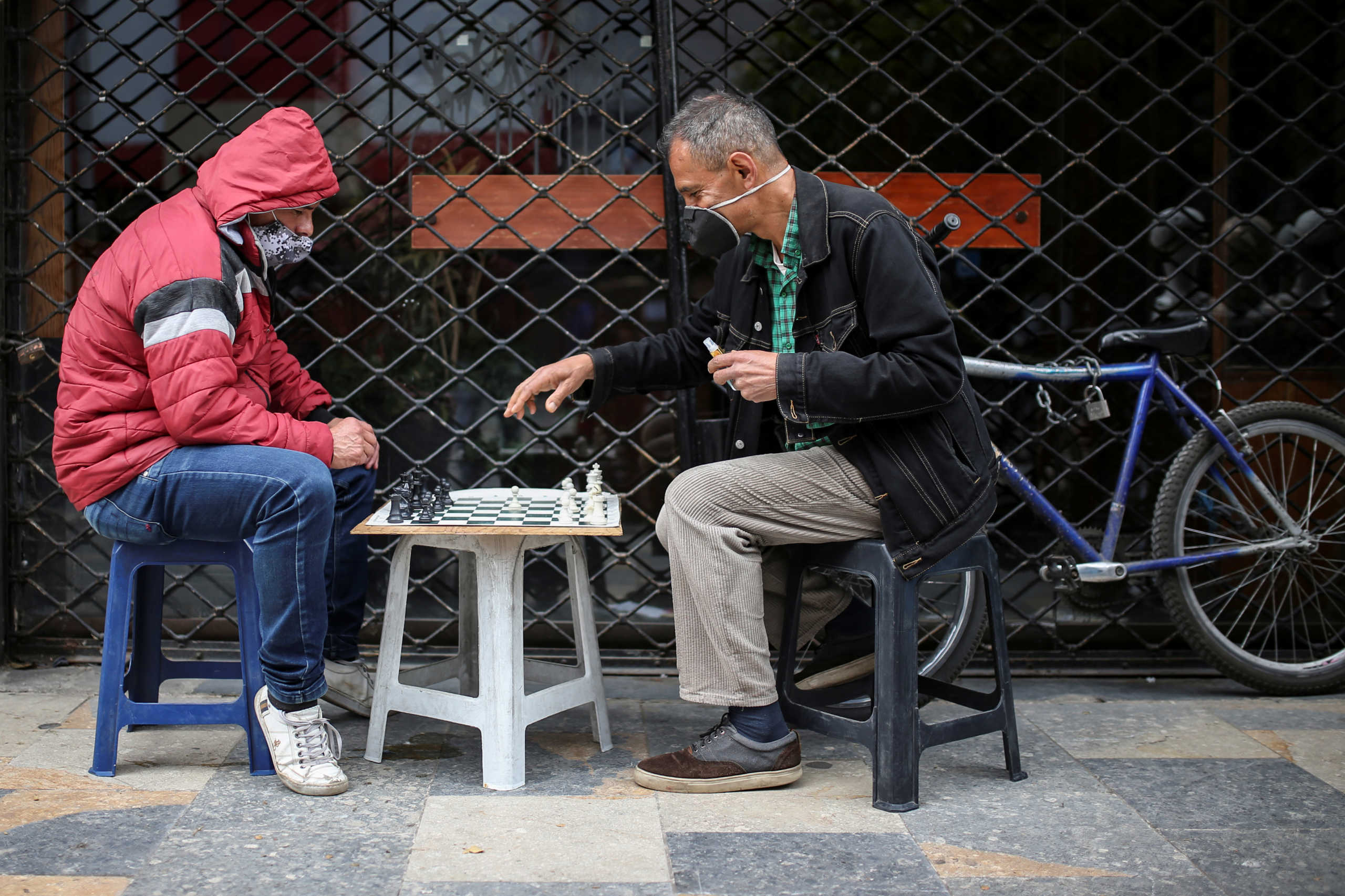 Men wearing face masks play chess on a street during the government-mandated quarantine to lower the rates of contagion from the coronavirus disease (COVID-19) outbreak, in Bogota, Colombia July 27, 2020. REUTERS
