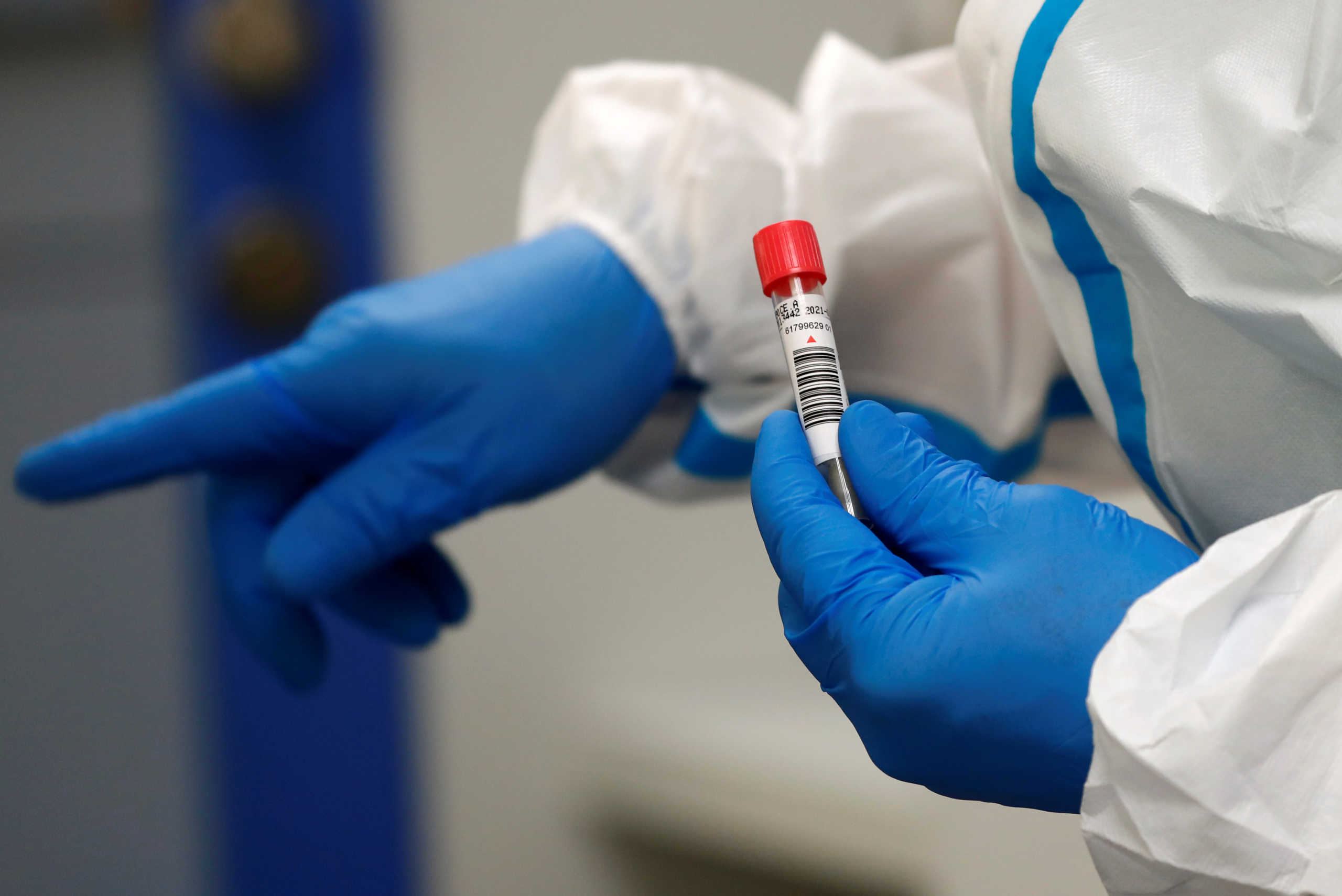 A German Red Cross medical staff holds a traveller's coronavirus disease (COVID-19) smear-test stick, who returned from the Ukraine, and was voluntary taken at the new Corona test station of the central bus location in Berlin, Germany, August 5, 2020. REUTERS