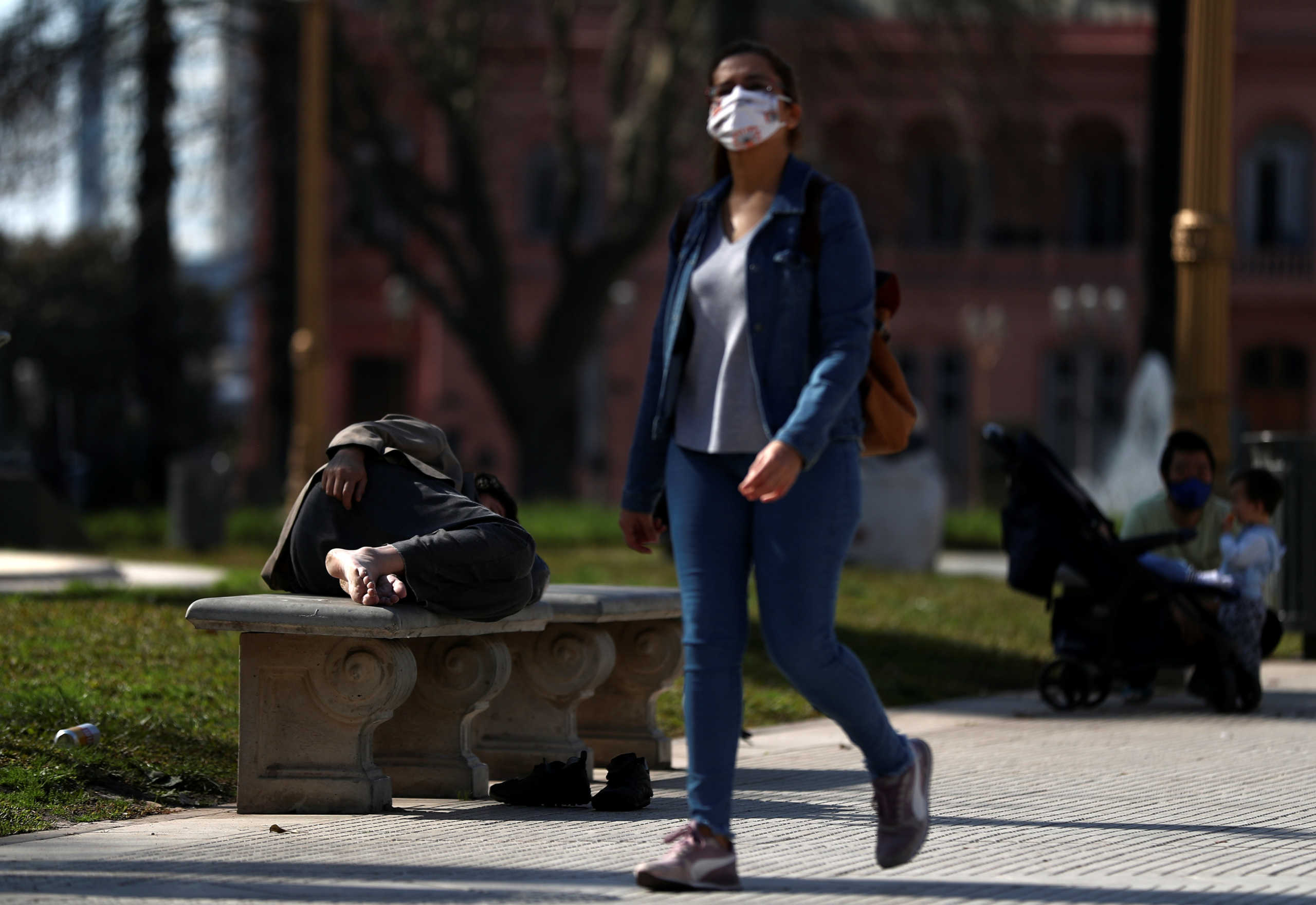 A homeless man sleeps on a bench outside the Casa Rosada Presidential Palace during the coronavirus disease (COVID-19) outbreak, in Buenos Aires, Argentina August 4, 2020. REUTERS