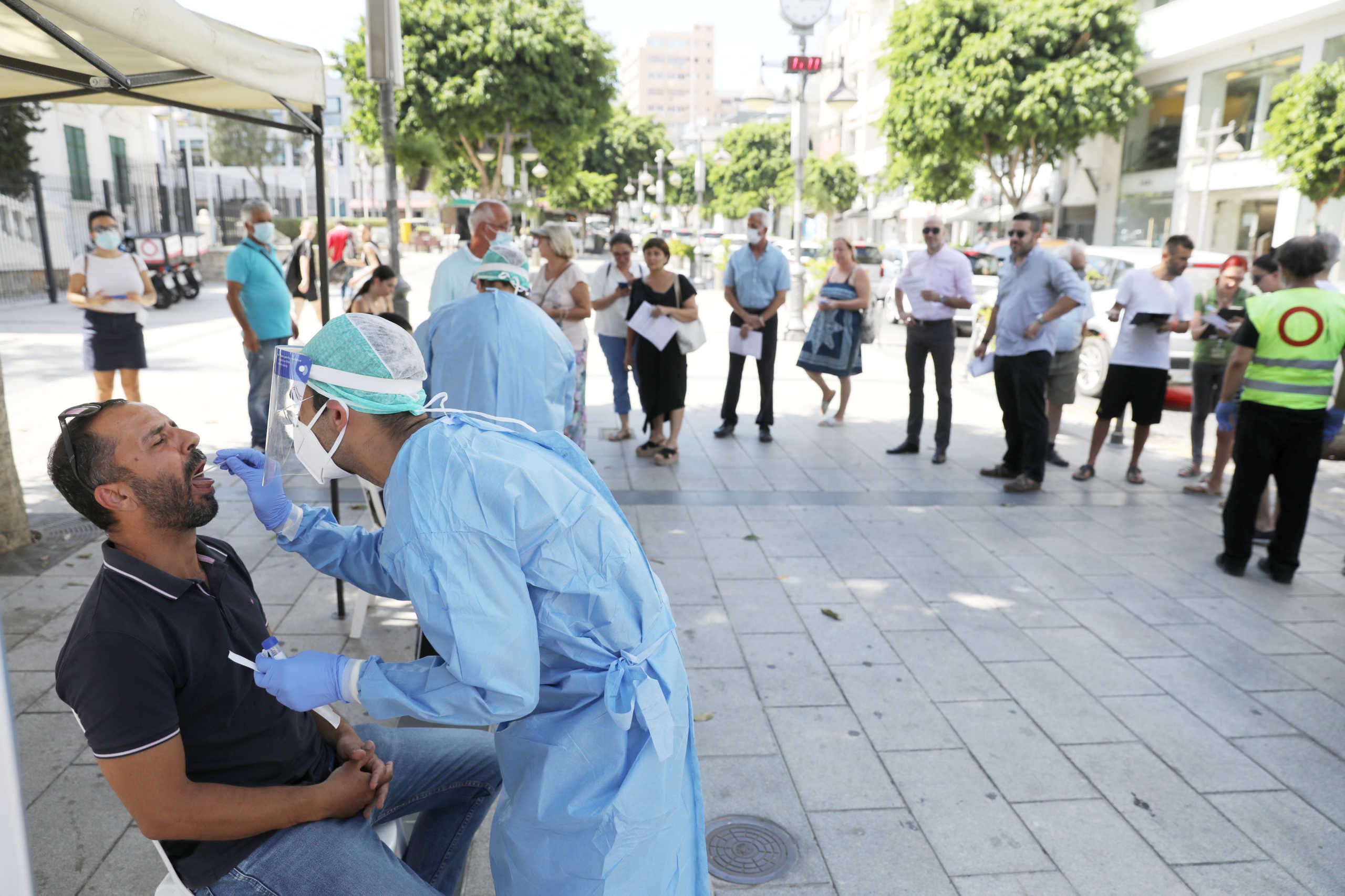 A medical health worker in a Personal Protective Equipment (PPE) collects a sample from a man using a swab, during a voluntary  coronavirus disease (COVID-19) test in Limassol, Cyprus, July 29, 2020. REUTERS