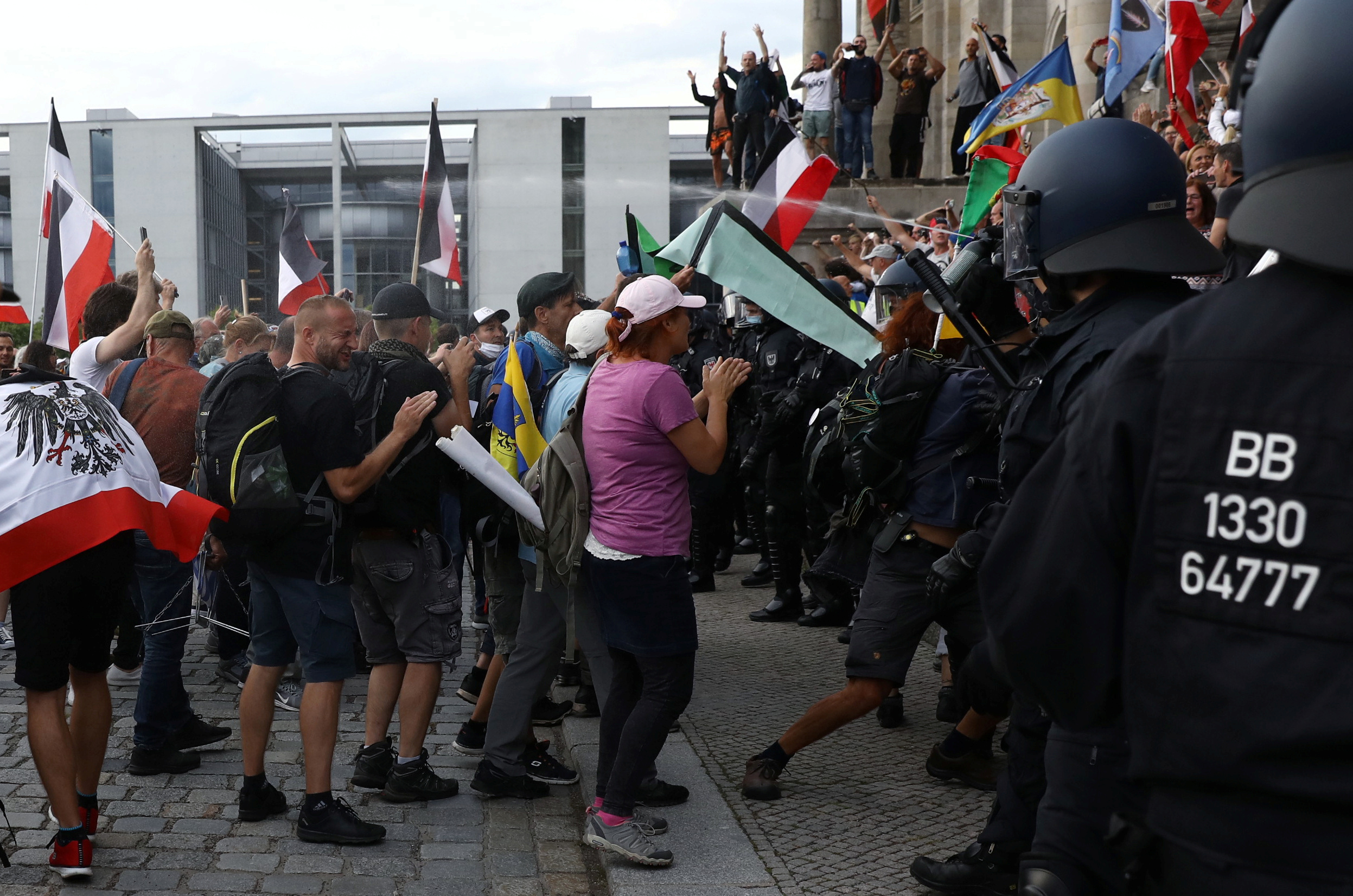 A police officer uses a pepper spray on protesters in front of the Reichstag Building during a rally against the government's restrictions following the coronavirus disease (COVID-19) outbreak, in Berlin, Germany, August 29, 2020. REUTERS